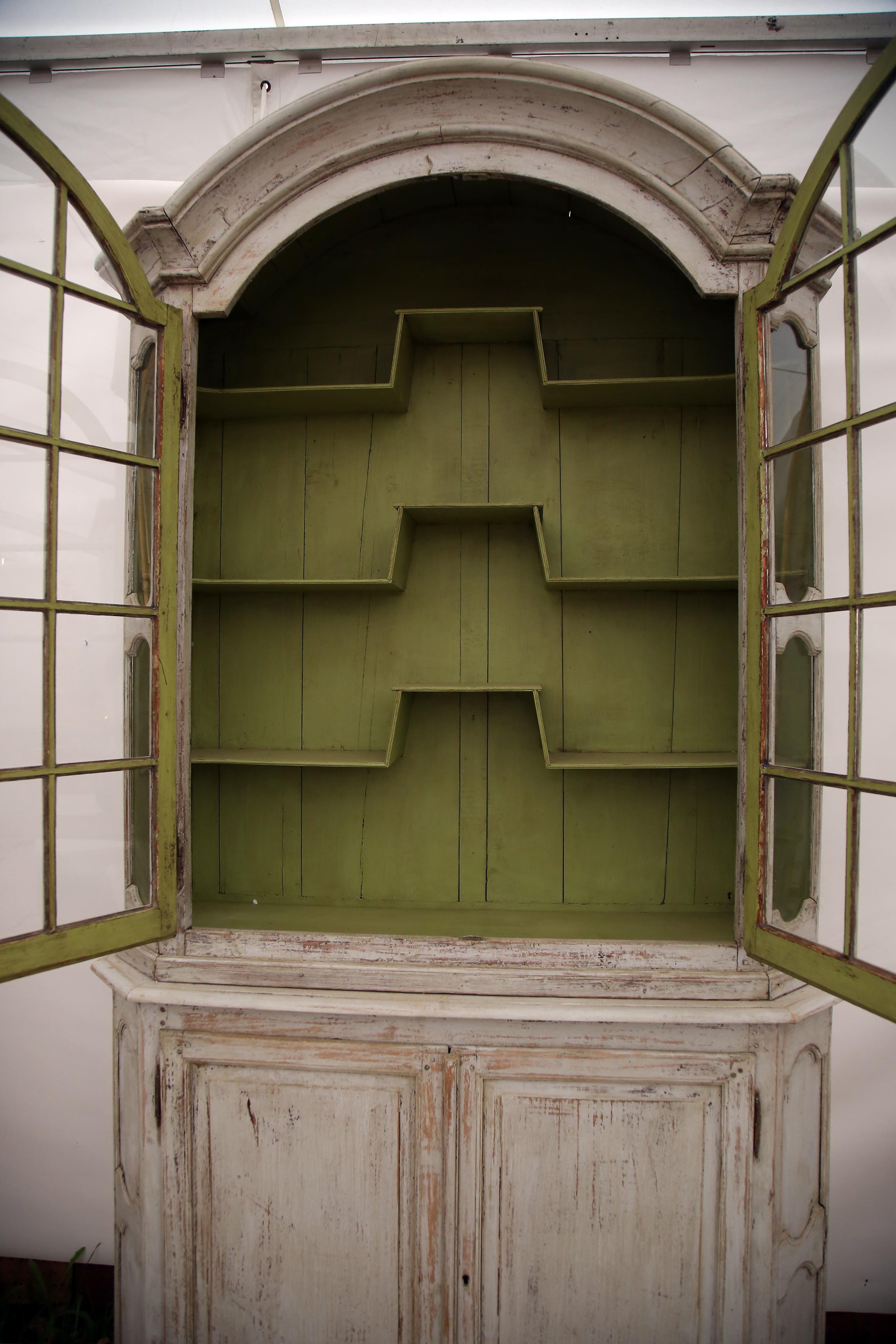 What a stunning piece! This breathtaking 19th century French cabinet features 2 doors on the upper cabinet with a unique shelving arrangement with a beautiful vibrant green hue painted over the shelves and backdrop. The upper cabinet is perfect for