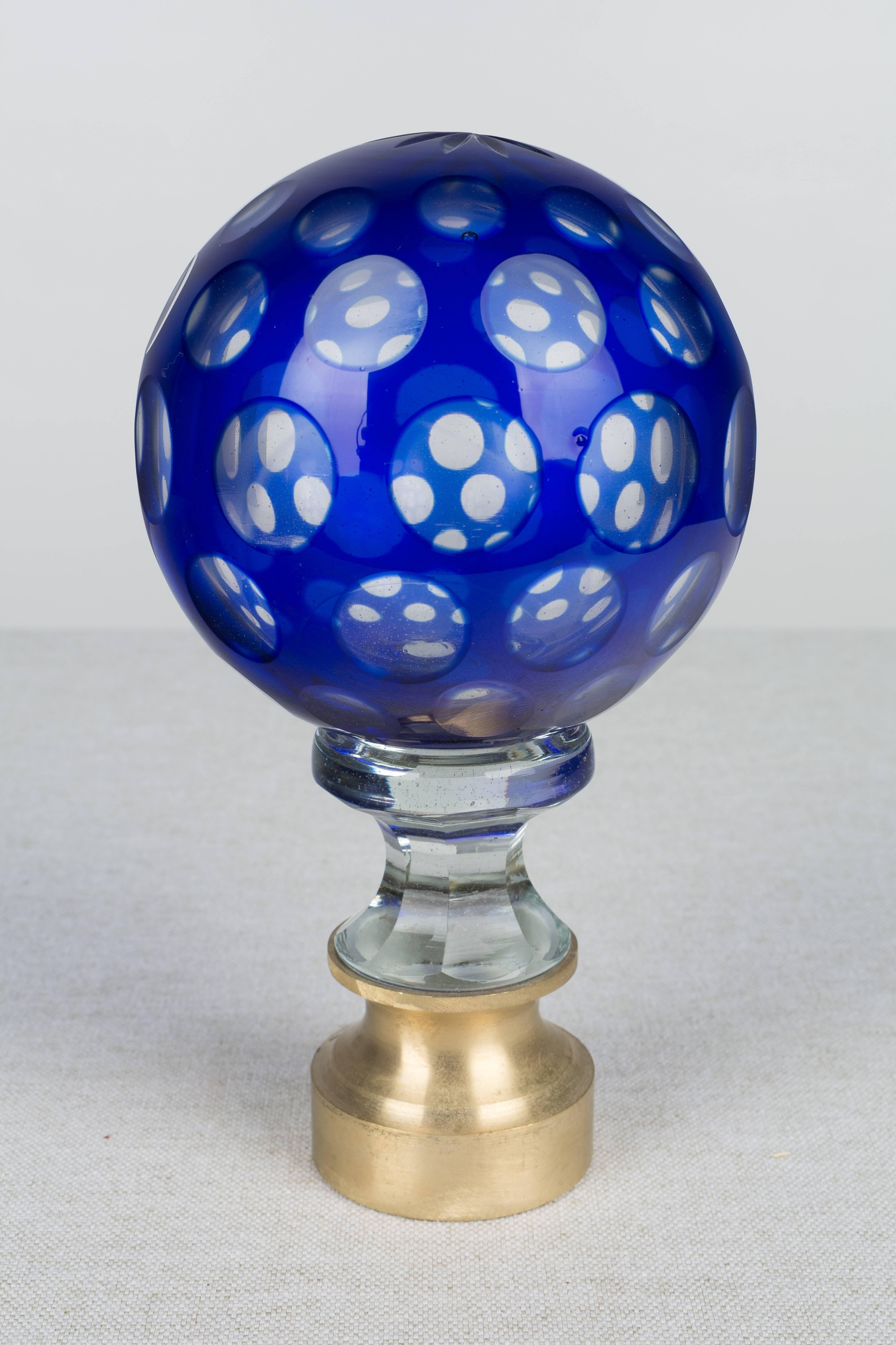 A 19th century French crystal newel post finial or boule d'escalier. These wonderful finials were used as decorative elements at the bottom of a staircase on the newel post. This one is made of two layers of cased glass with the cobalt glass surface