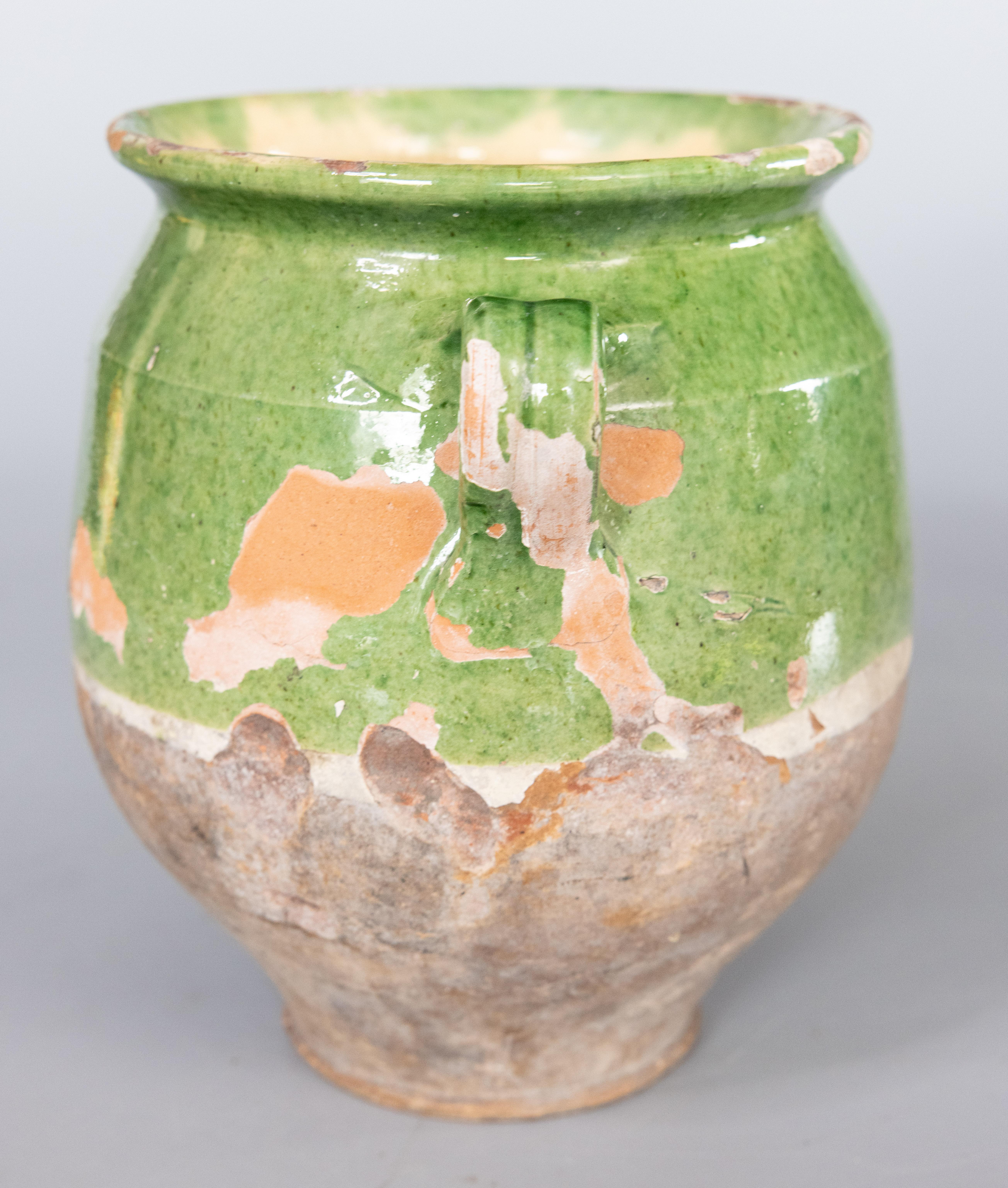 Antique 19th century French confit pot with green glaze from the South of France, Castelnaudary. This pot or planter is hand thrown with charming handles known as 'ears'. These jars were used for storing and preserving cooked meat. It displays