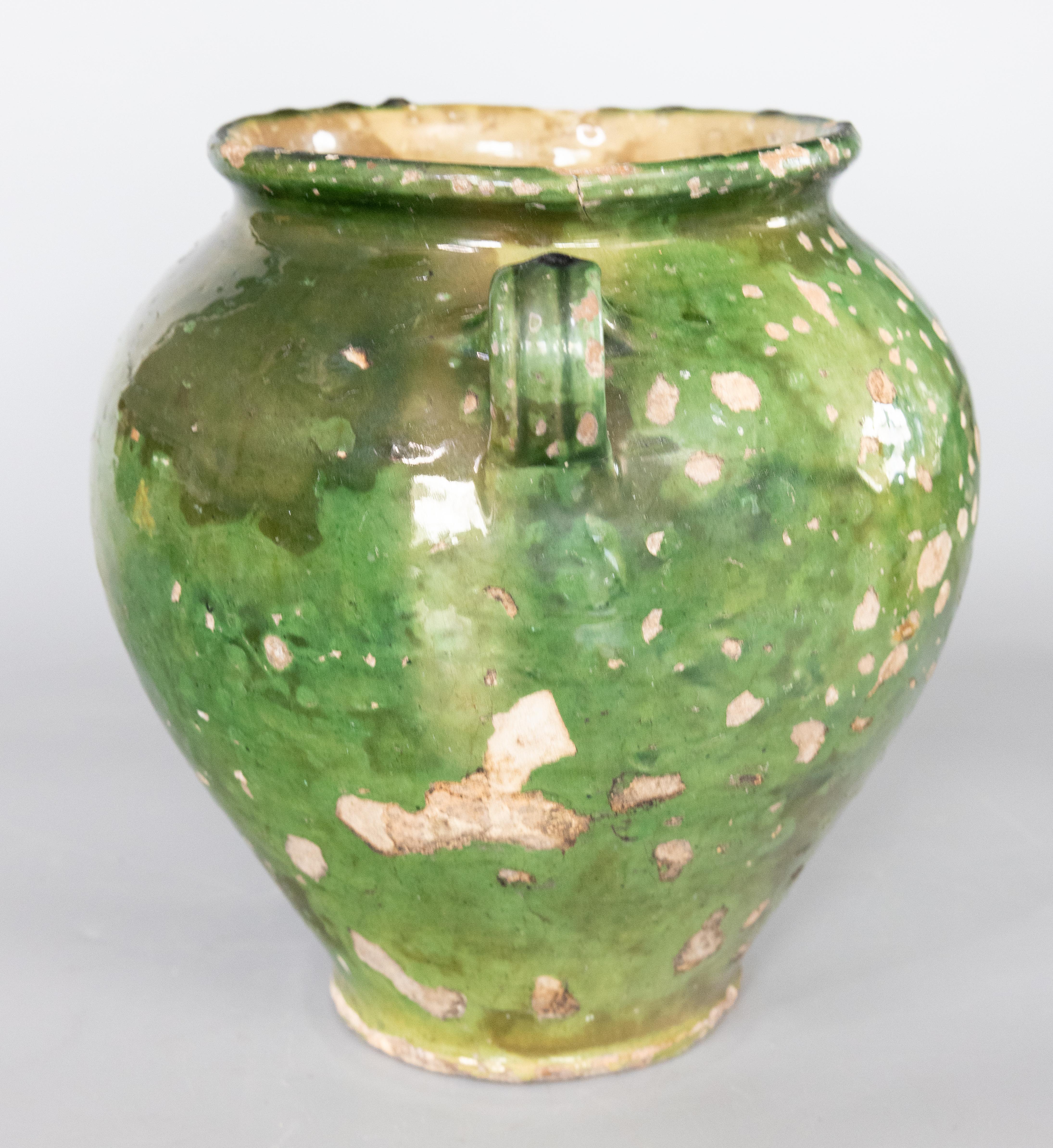 Antique 19th century French confit pot with green glaze from the South of France, Castelnaudary. This pot or planter is hand thrown with charming handles known as 'ears'. These jars were used for storing and preserving cooked meat. It displays