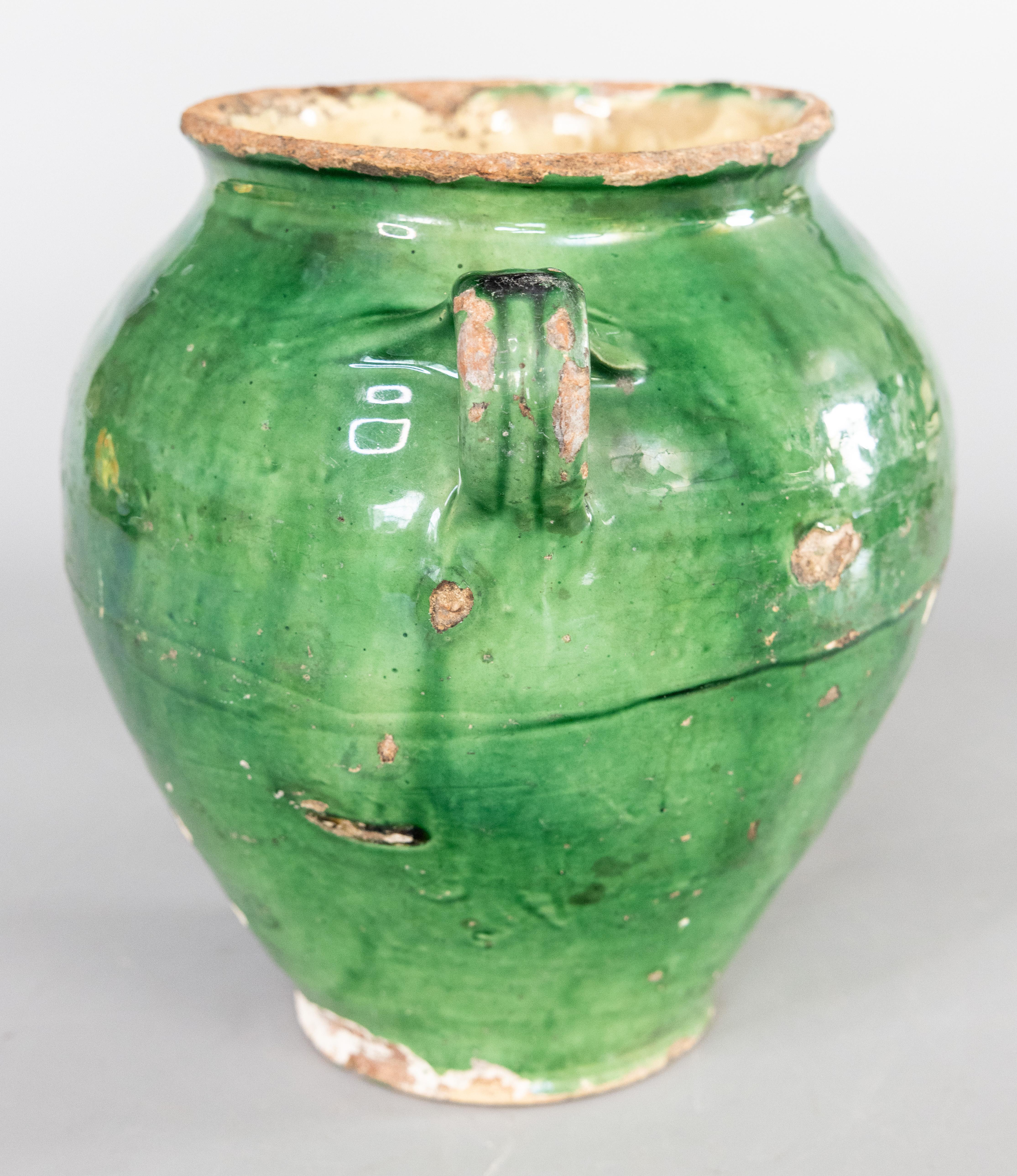 Antique 19th century French confit pot with green glaze from the South of France, Castelnaudary. This pot or planter is hand thrown with charming handles known as 'ears'. These jars were used for storing and preserving cooked meat. It displays