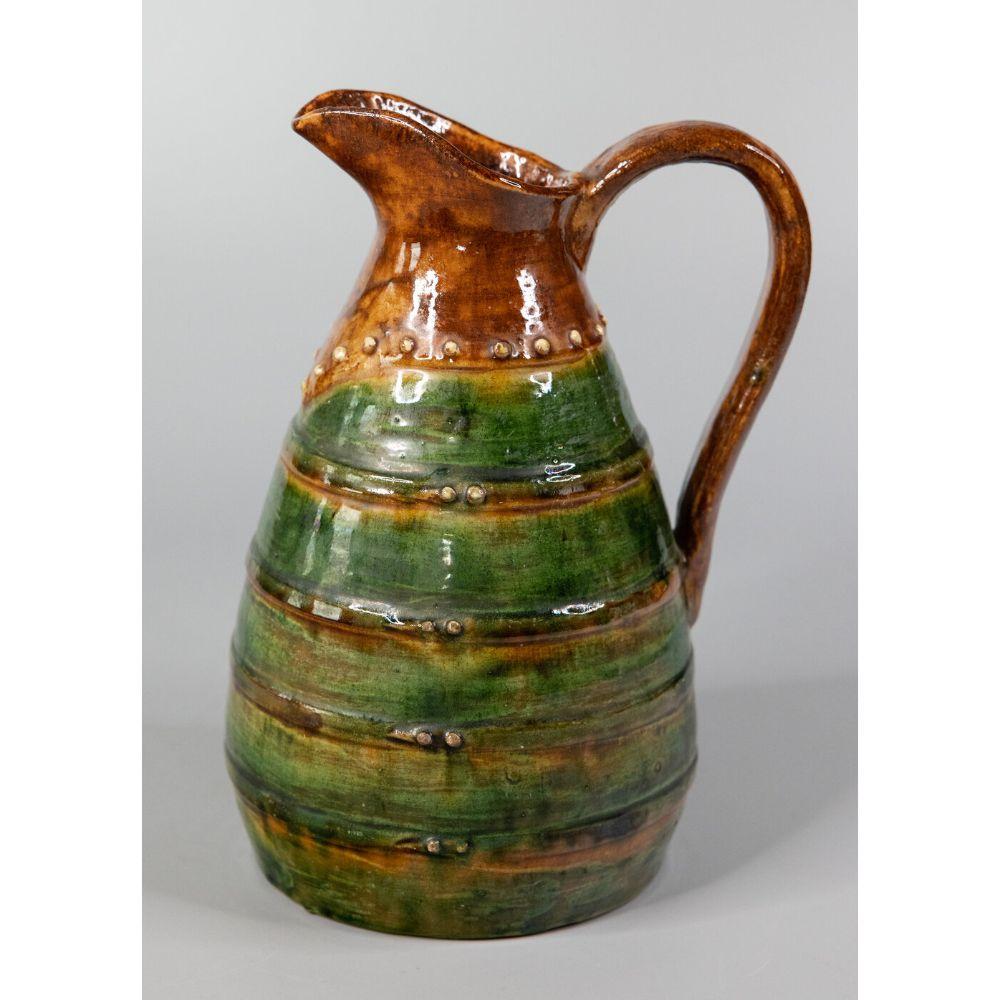 A lovely 19th century French country earthenware terra cotta pitcher or water jug with green glaze. This charming jug has a simple shape and organic design, perfect with a bouquet of flowers or beautiful displayed all on its own.

