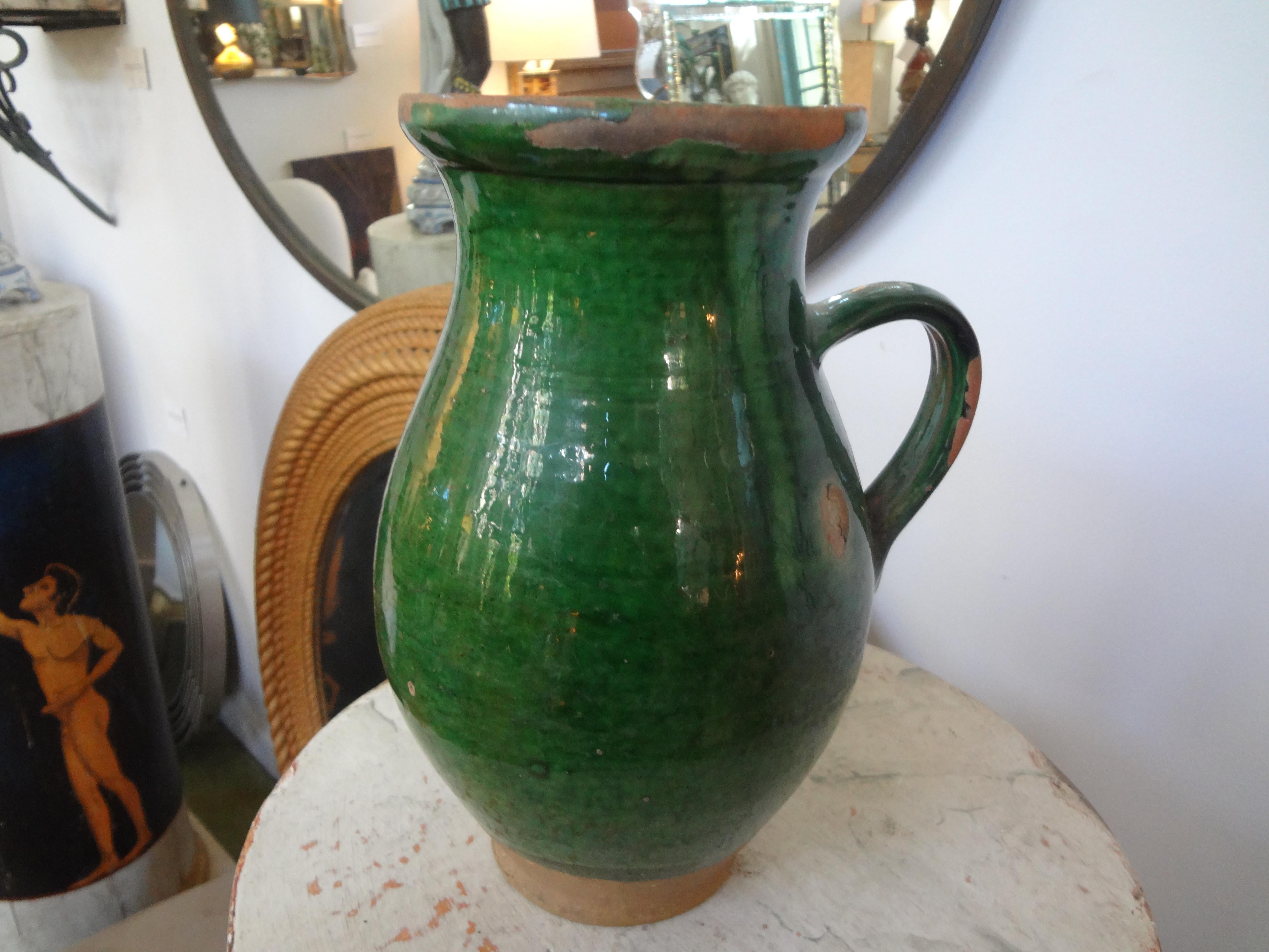 A 19th century French green glazed terracotta pottery vessel. This vessel was used for milk or as a vinegar pot (vinaigrier). These vessels were most often from the Southwest part of France. Our pot is in good condition with some losses to glaze.