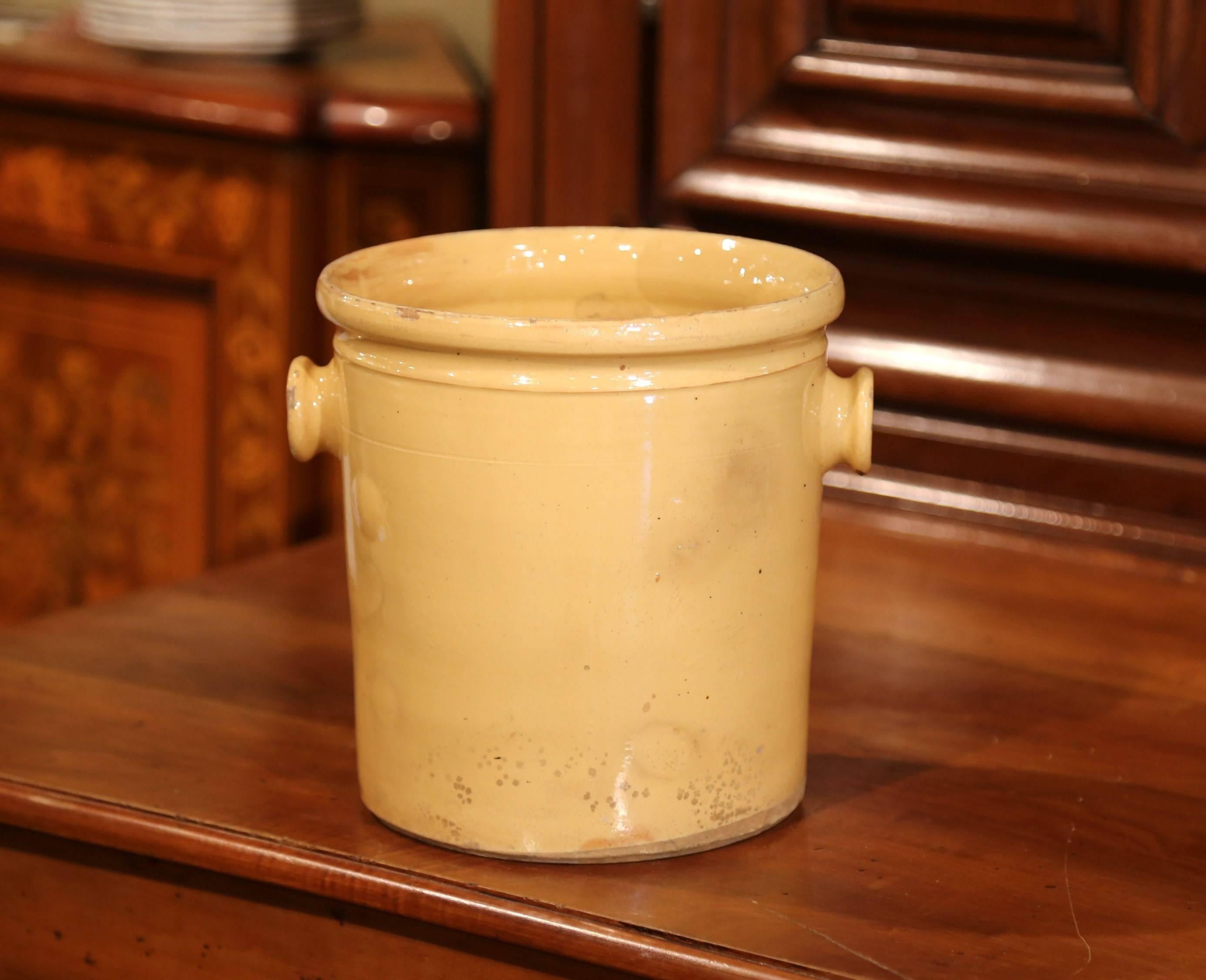 Place your kitchen utensils in this antique porcelain pot from Provence. Crafted in Southern France, circa 1860, the ceramic pot has a circular shape and simple design. The vase has a yellow glaze and a small round handle on both sides. The