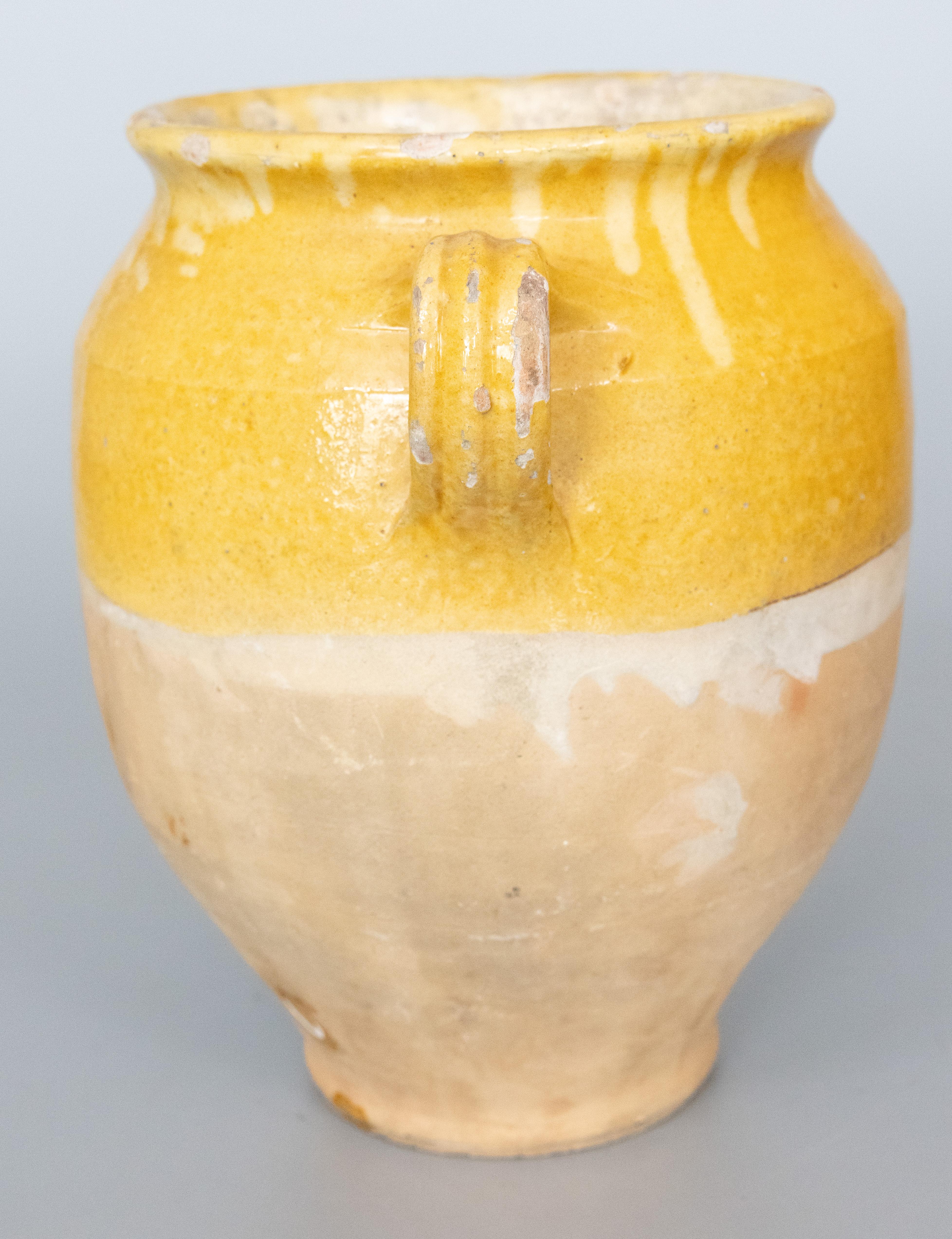 A lovely antique 19th century French confit pot with mustard yellow glaze from the South of France, Castelnaudary. This pot or planter is hand thrown with charming handles known as 'ears'. These jars were used for storing and preserving cooked meat.