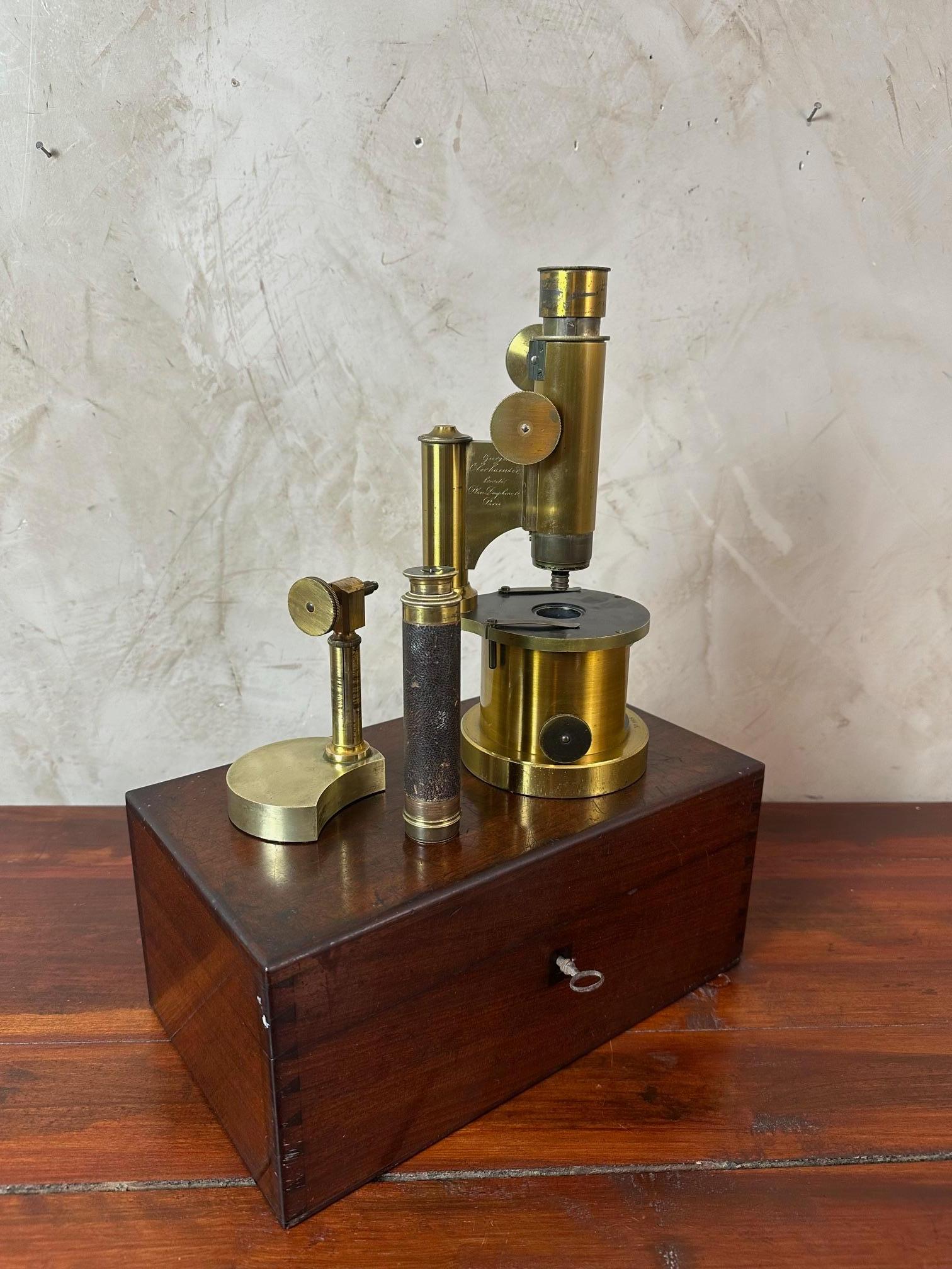 Beautiful object! A variable-magnification achromatic microscope from the 1850s (19th century) made of brass, presented in its original wooden boxe with key. Signed by the inventor of this type of microscope, Mr. Georges Oberhaueser, in his workshop