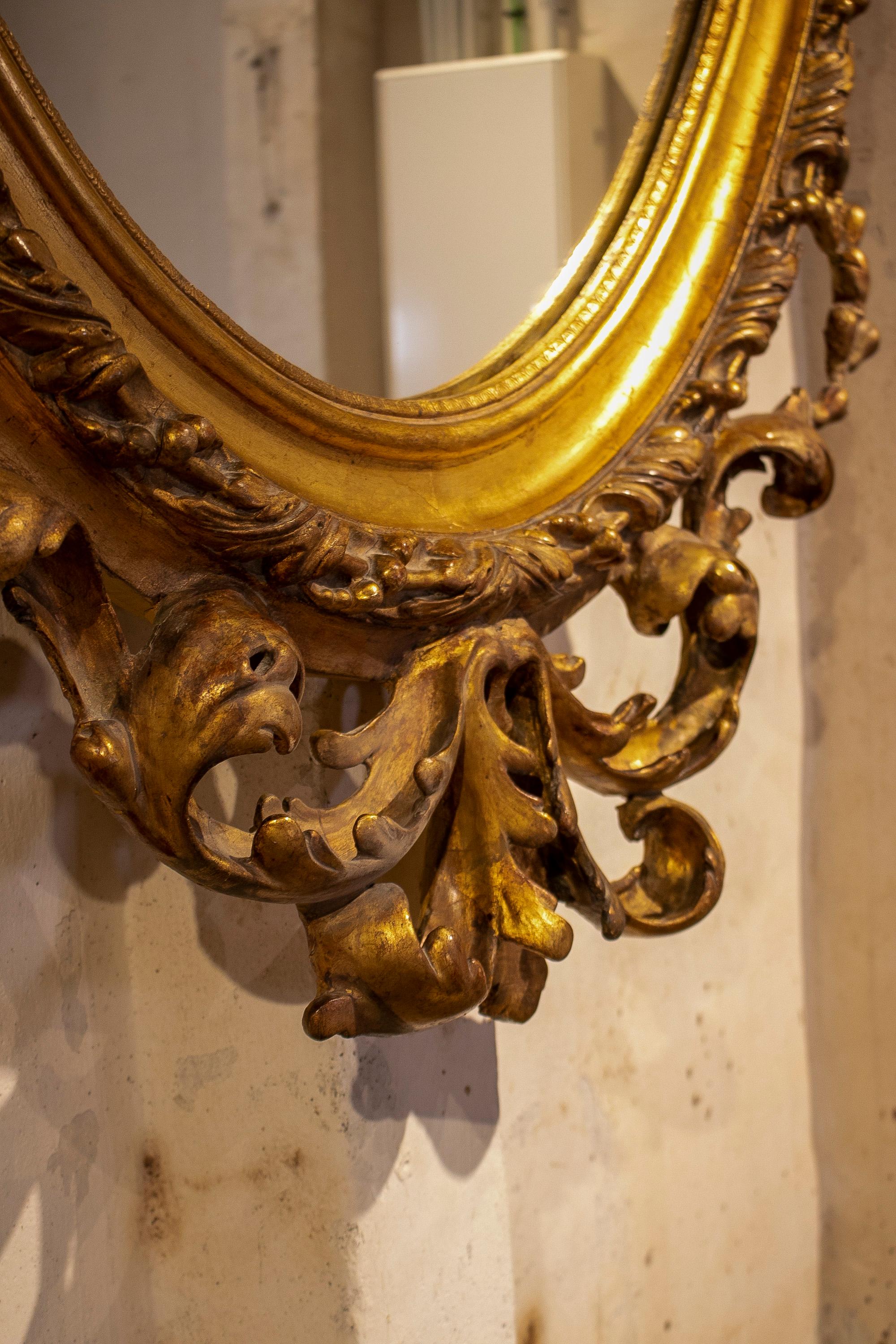 Espejo ovalado francés del siglo XIX de madera dorada con cresta y rocalla barroca en venta 10