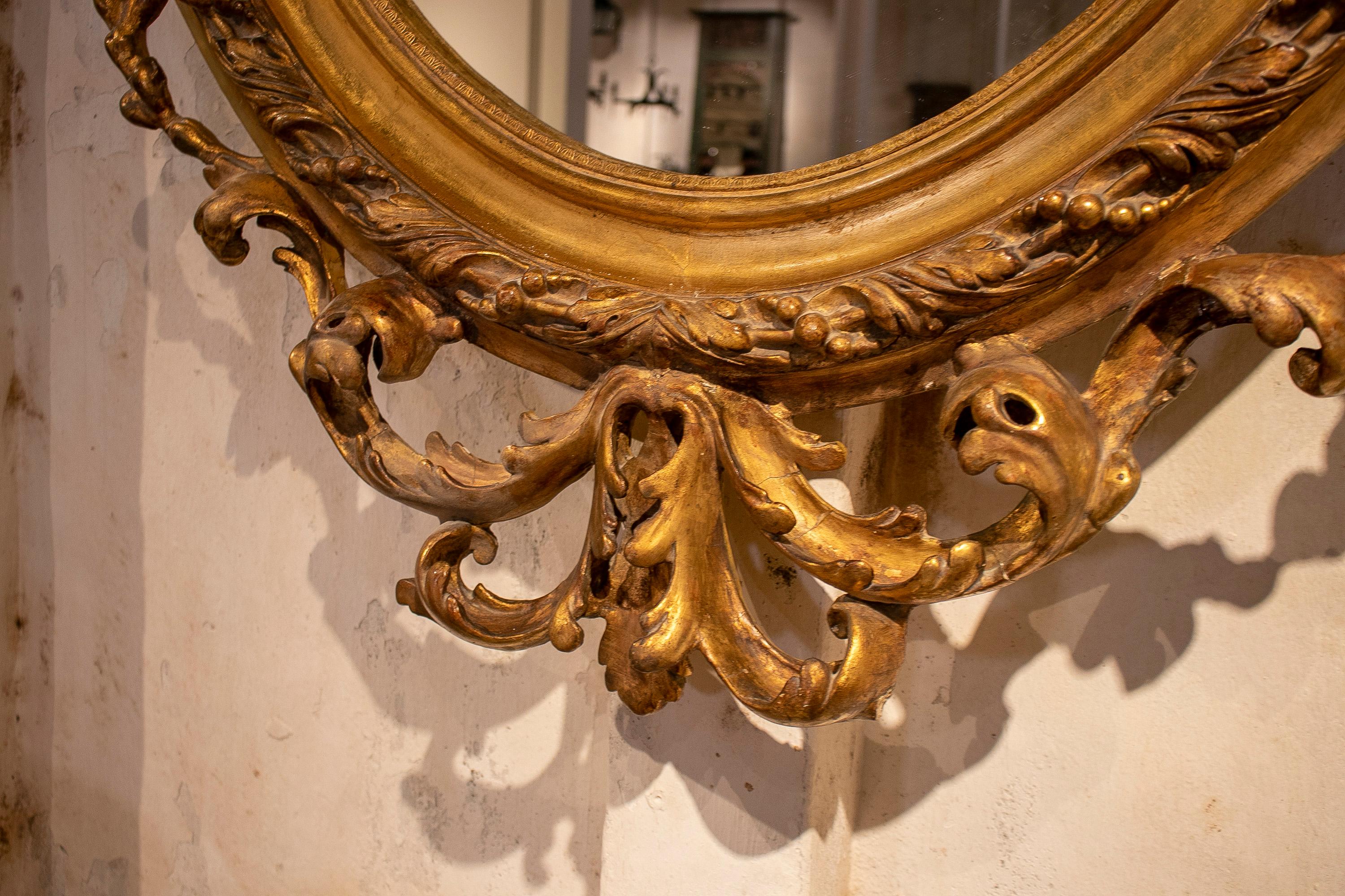 Espejo ovalado francés del siglo XIX de madera dorada con cresta y rocalla barroca Madera en venta