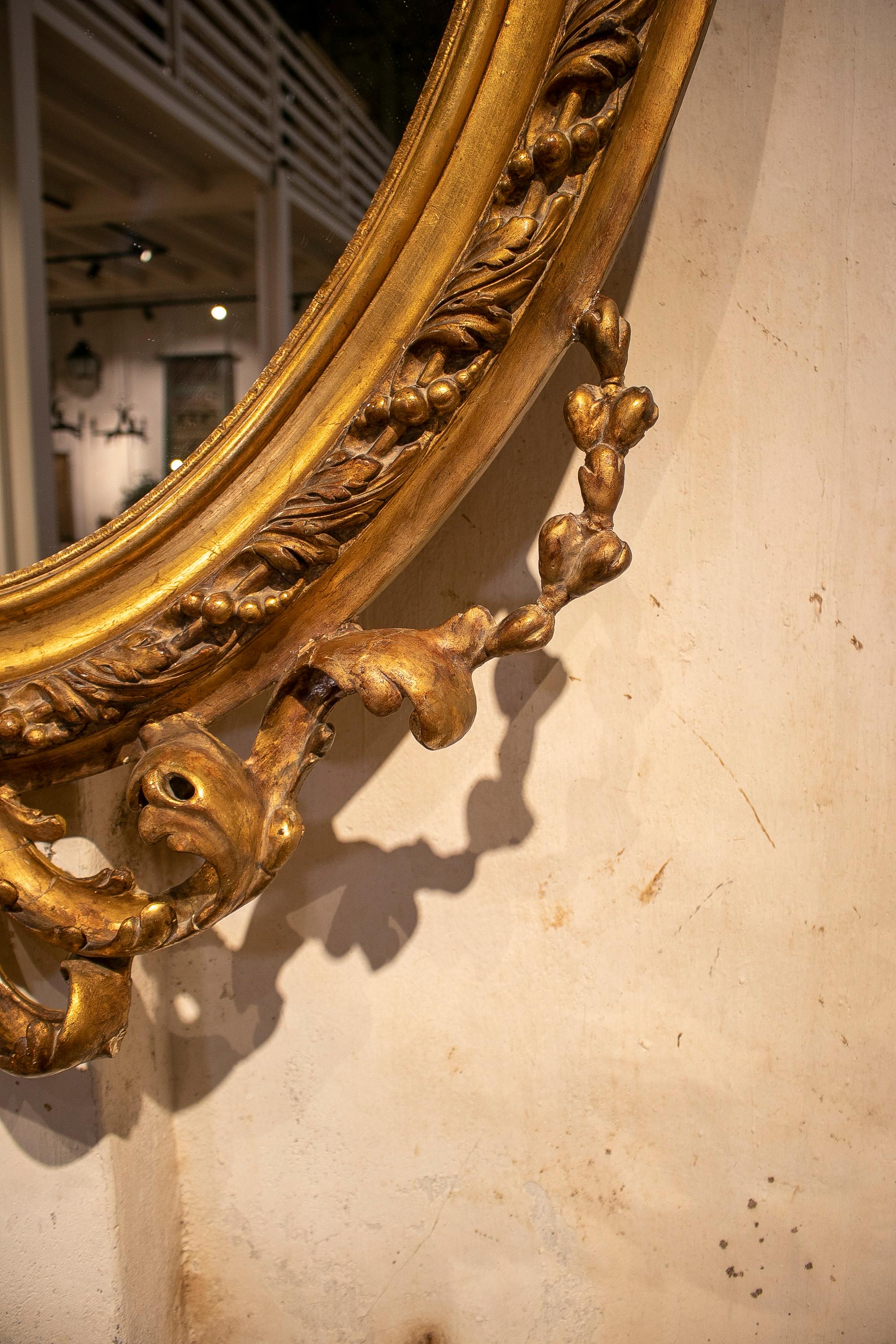 Espejo ovalado francés del siglo XIX de madera dorada con cresta y rocalla barroca en venta 1