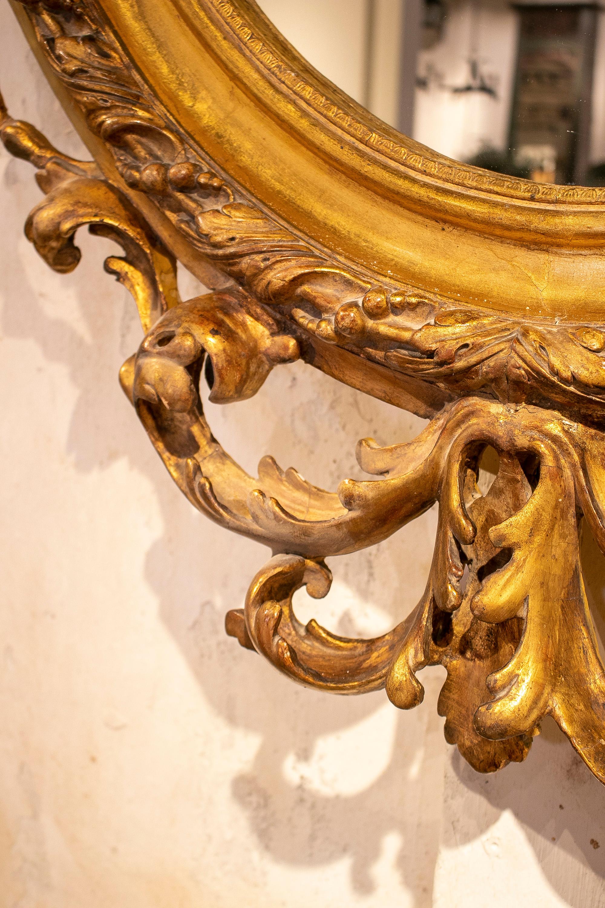 Espejo ovalado francés del siglo XIX de madera dorada con cresta y rocalla barroca en venta 3