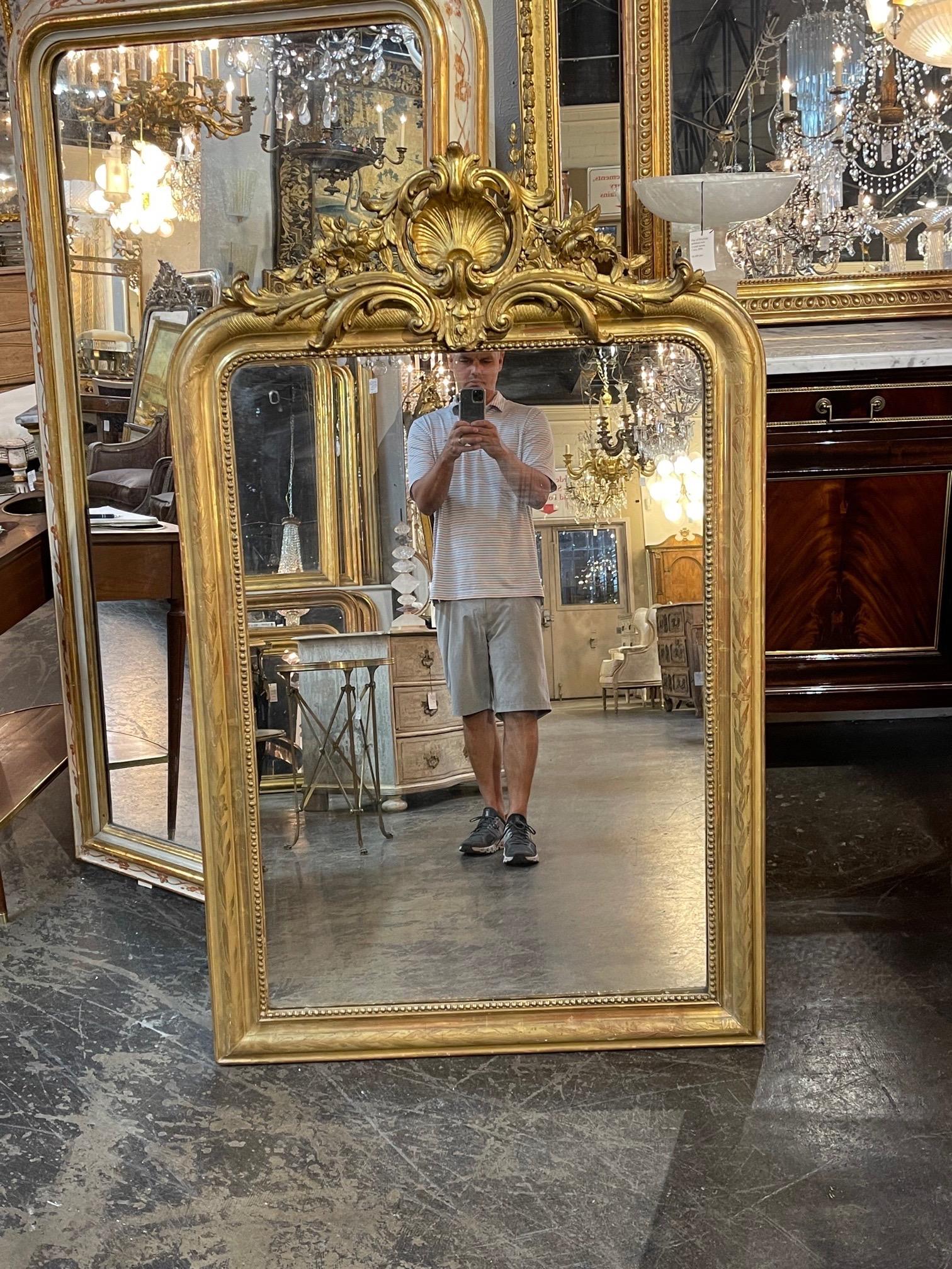 Very fine 19th century French gold Louis Philippe mirror with a beautifully carved crest at the top. There is also a floral pattern on the wood along with a beaded inner border. A real touch of elegance for a fine home!