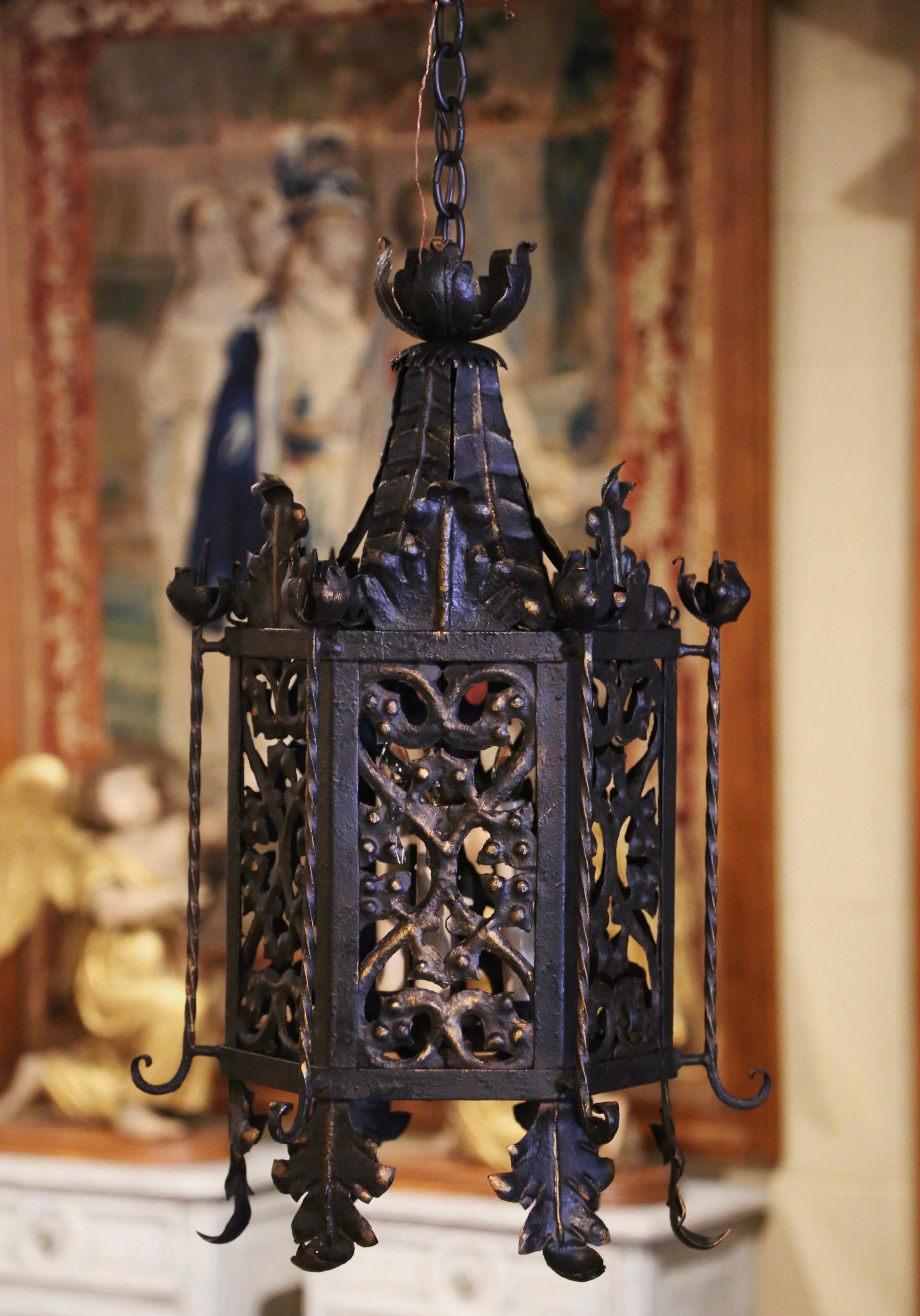 Crafted in France circa 1880, and hexagonal in shape with slant roof form top, the antique light fixture features pierced ornate, decorative scrolls throughout and embellished with acanthus leaf and floral motifs. The lantern has three inside lights