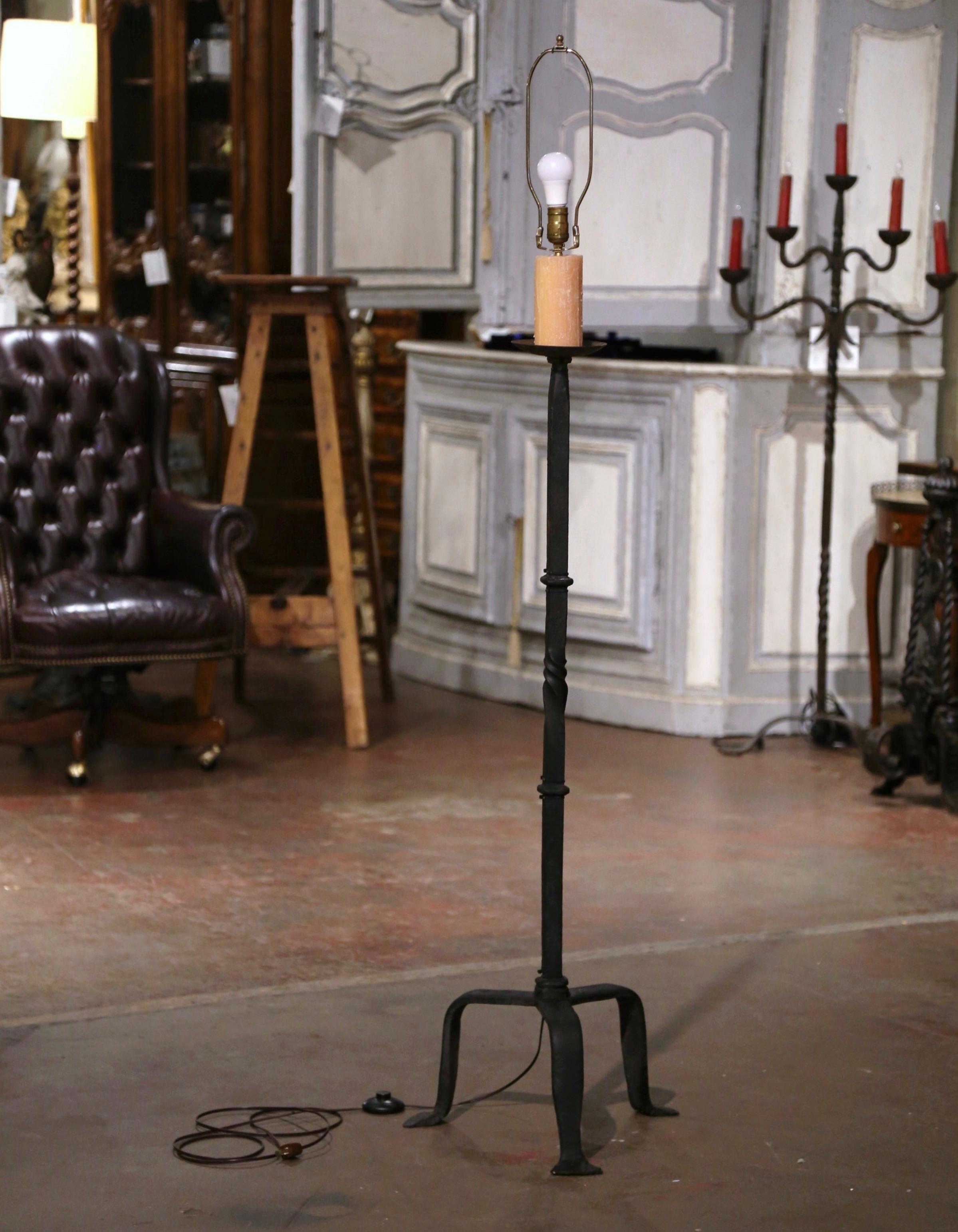 Decorate a study of office with this elegant floor fixture. Crafted in southern France, circa 1860, the candelabra lamp stands on a tripod base ending with three small feet. The twisted stem is topped with a single light with new wiring. The light
