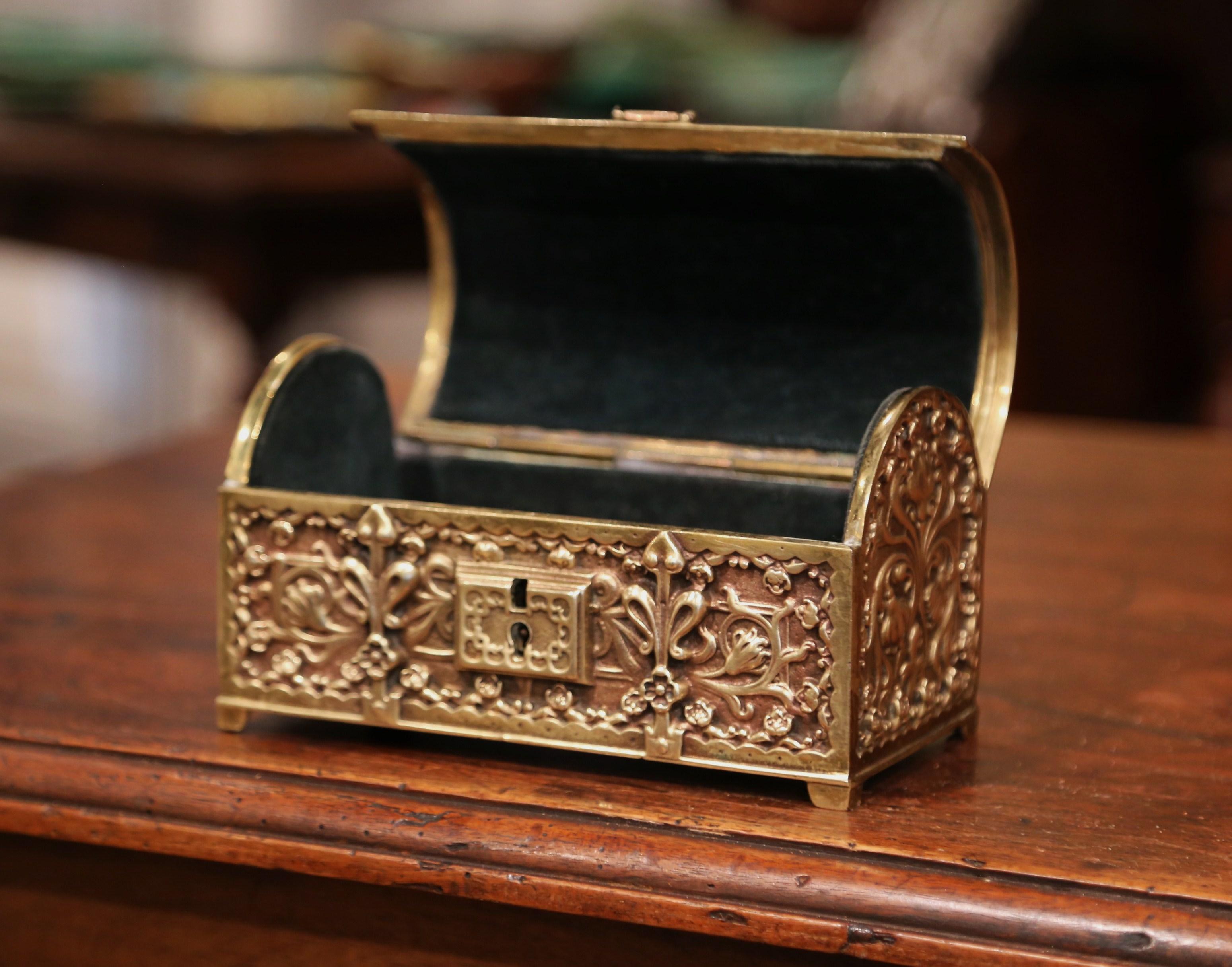 This antique gilt bronze casket was created in France, circa 1870. The miniature trunk-shaped box has a bombe top with handle, and is embellished with intricate floral and leaf decor on all four sides. The jewelry box is decorated with a classic