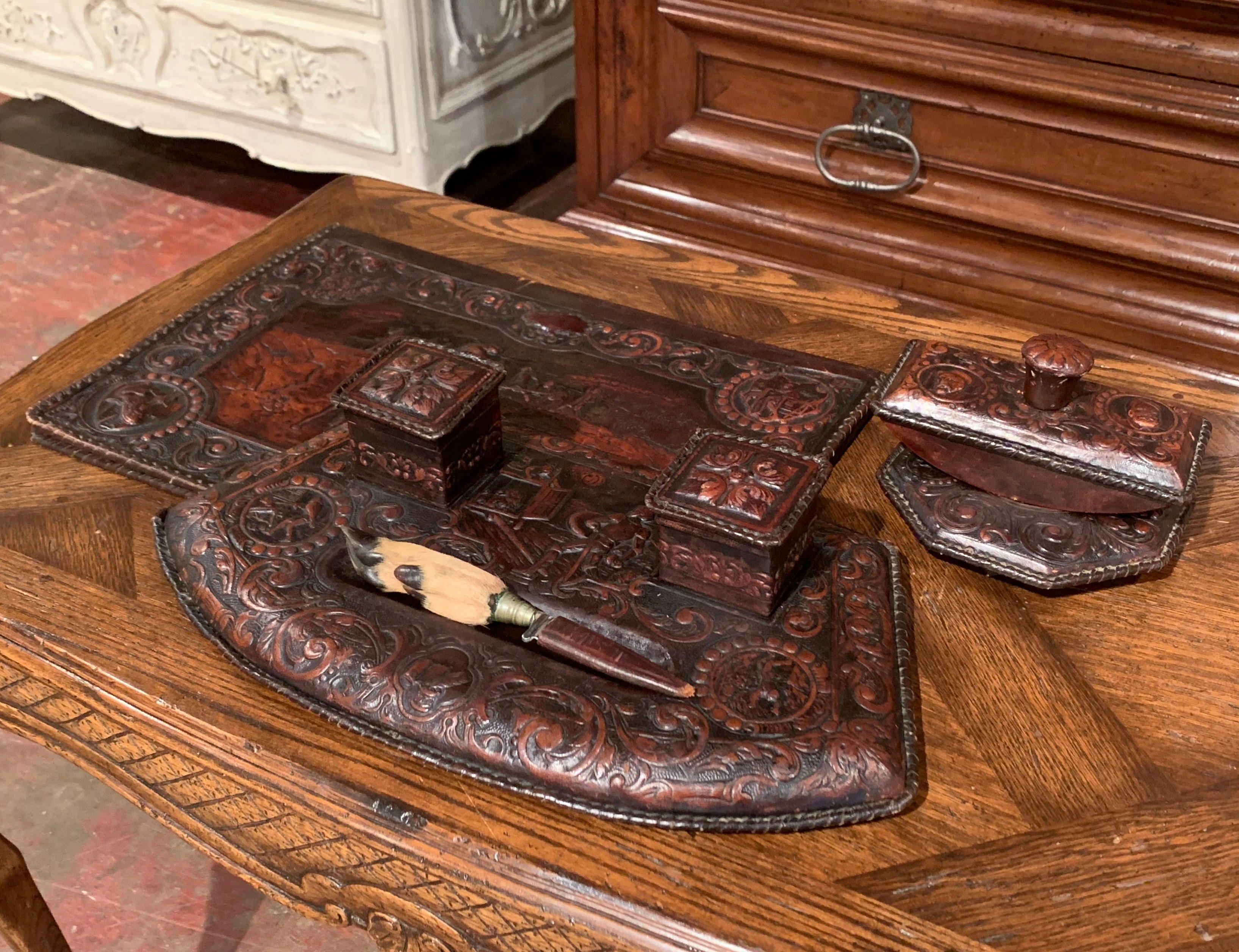 Decorate a man's office desk with this elegant Gothic set; created in France circa 1860 and made of brown embossed and repousse leather, the desk set have five pieces comprising a large pad, a holding tray with letter opener embellished with deer