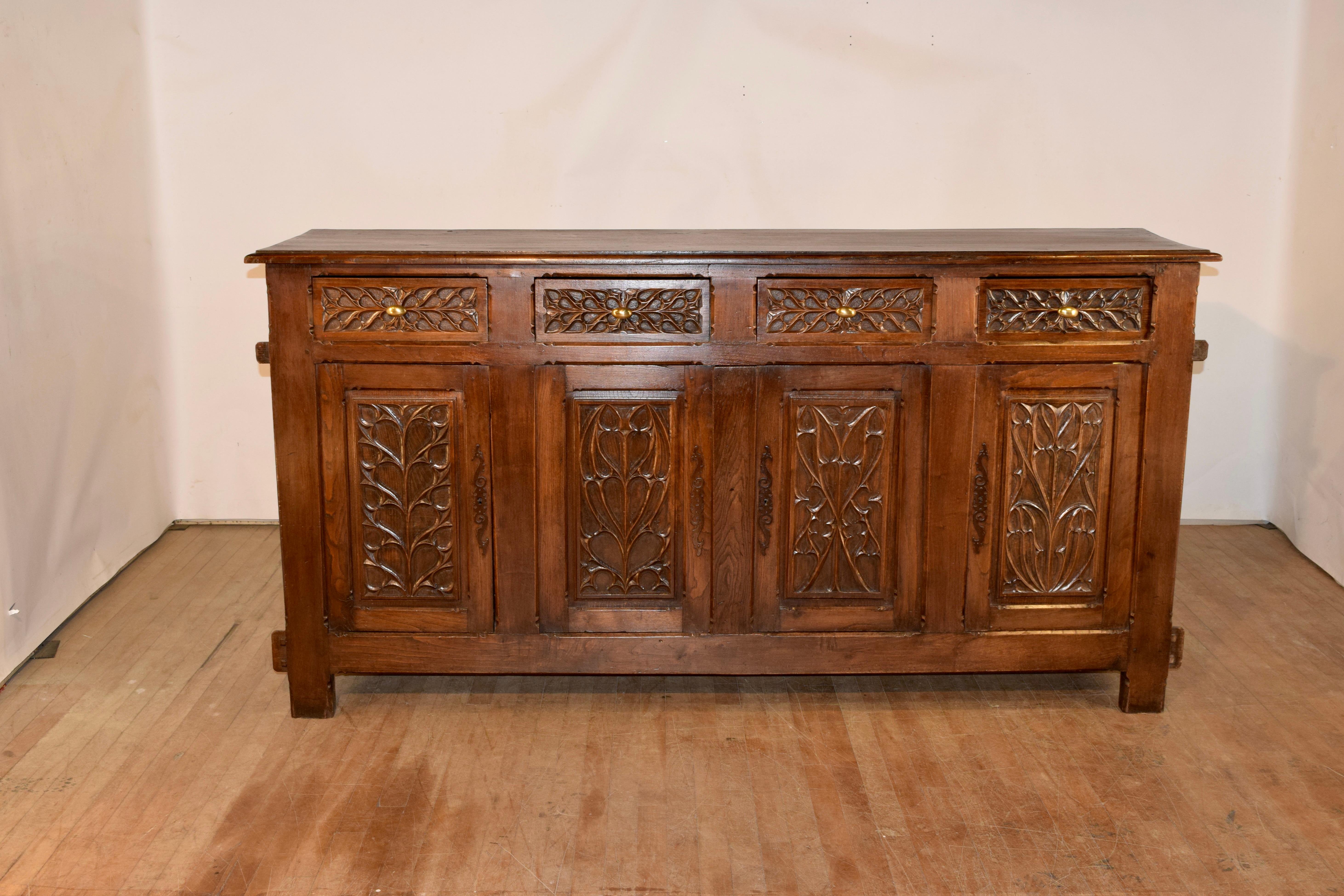 19th century French gothic enfilade with a plank top which has a beveled edge, following down to lovely hand paneled sides and four drawers over four doors in the front. The drawer fronts and door panels are exquisitely hand carved, and the doors