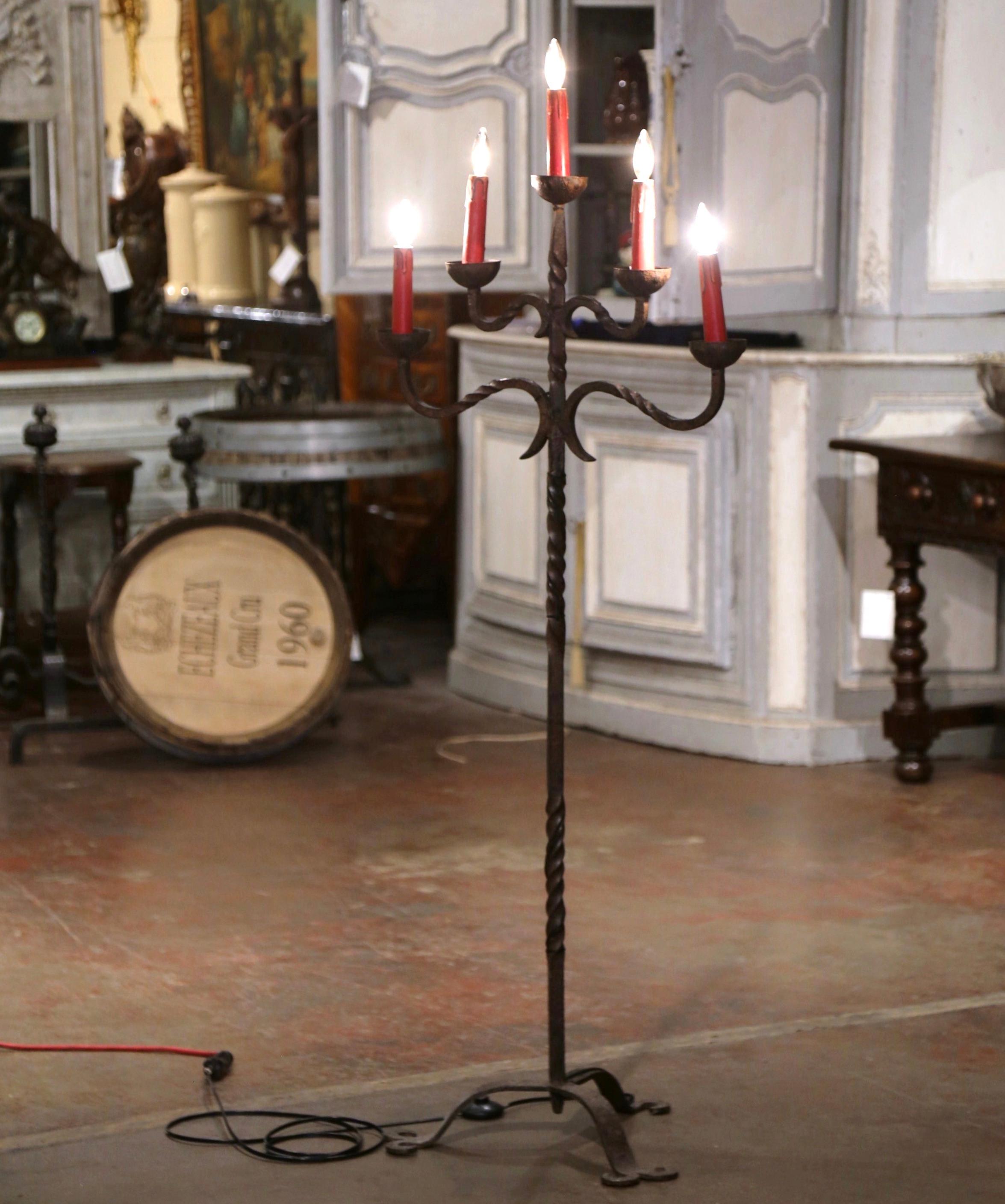 Décorez un bureau ou une étude avec cet élégant luminaire de sol. Fabriquée dans le sud de la France, vers 1860, la lampe candélabre repose sur une base tripode terminée par trois pieds. La tige torsadée est surmontée de cinq bras courbes, tous