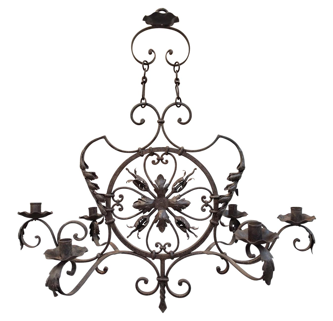 Large decorative forged iron chandelier, late 19th century. Forged in France, circa 1890, the large chandelier can receive 6 candles (candles not provided). On wavy shapes, the chandelier is decorated with leaves and flowers in forged iron. The