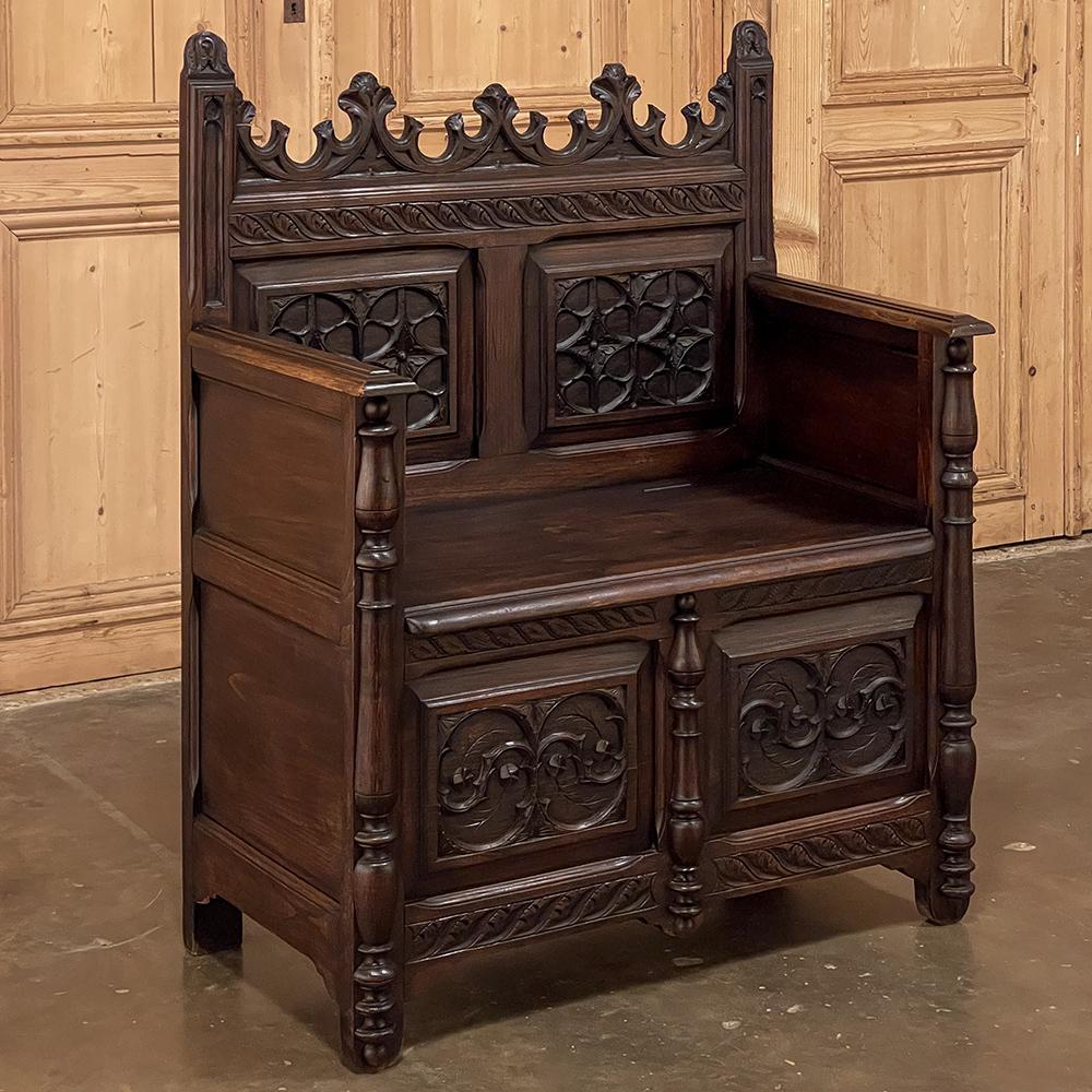 19th Century French Gothic hall bench ~ Caquetoire is a celebration of the style, rendered from beautiful walnut and commanding a stately presence regardless of its diminutive size! Such items were frequently designed as special seats for visiting