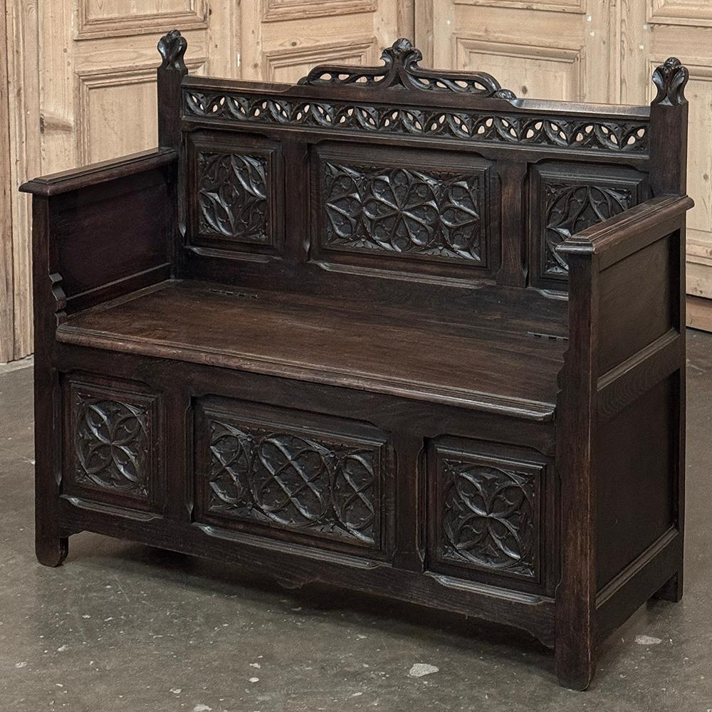 19th Century French Gothic Hall Bench was hand-crafted from solid old-growth oak, and features a tailored classical architecture with design embellishments that are definitive of the style.  A two-tiered pierced gallery rail creates a crown on the