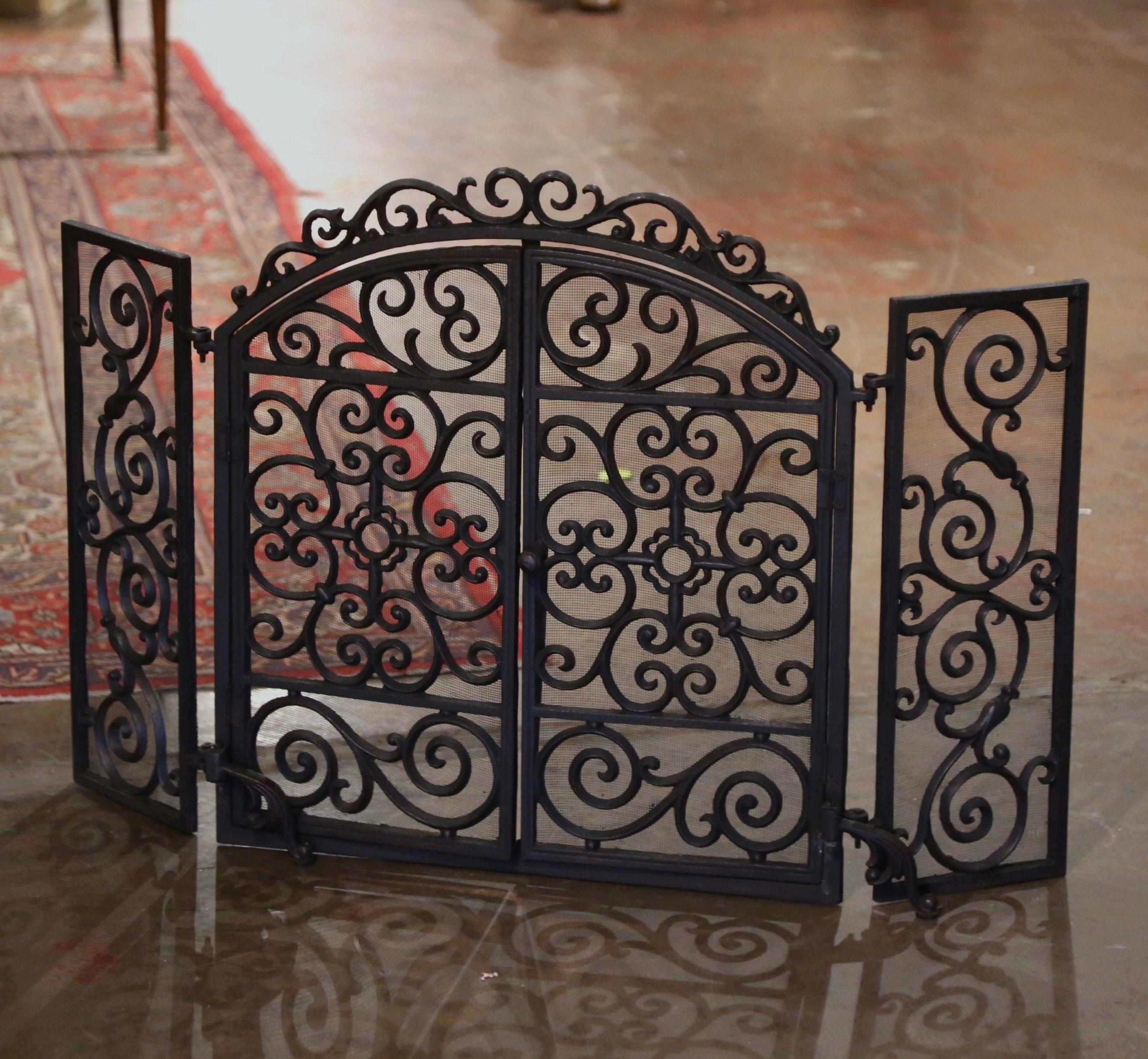 Decorate a fireplace hearth with this elegant and ornate antique iron screen. Forged in France circa 1880, the freestanding wrought iron piece with arched top stands on small front feet, and is dressed with two folding sides (8