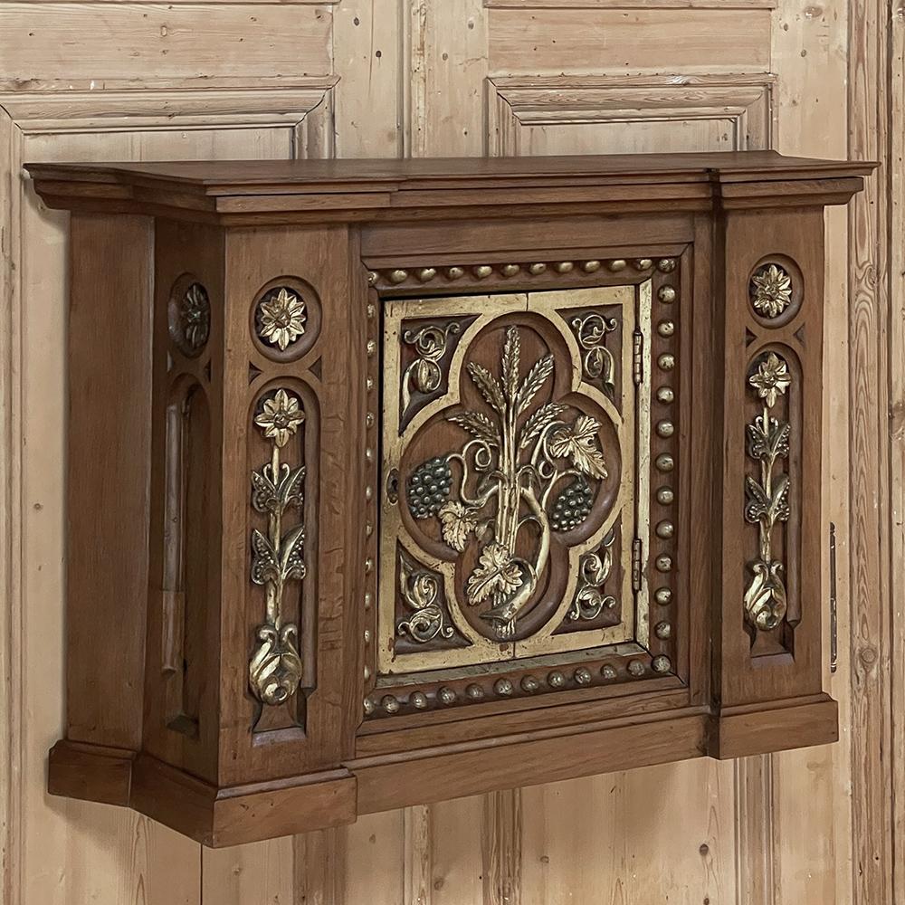 Cette armoire à sacrement de style gothique français du 19e siècle a été sculptée avec art dans du chêne et du bois fruitier massifs pour créer un remarquable artefact religieux conçu pour être apprécié à travers les âges ! La forme trapézoïdale de