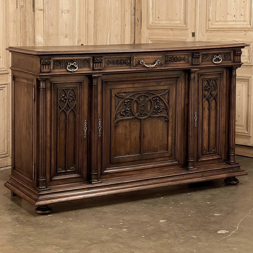 19th century French Gothic walnut buffet is a refined expression of the style which is considered one of the oldest furniture styles from France, dating back to the mid-12th century. This splendid example was rendered from sumptuous French walnut,