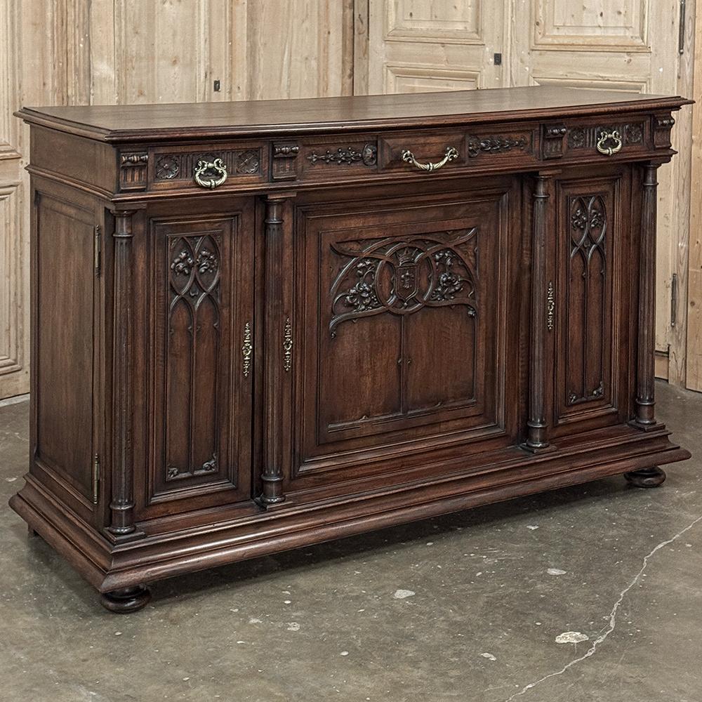Il buffet gotico francese in noce del XIX secolo è una raffinata espressione dello stile che è considerato uno dei più antichi stili di arredamento francese, risalente alla metà del XII secolo.  Questo splendido esemplare è stato realizzato in