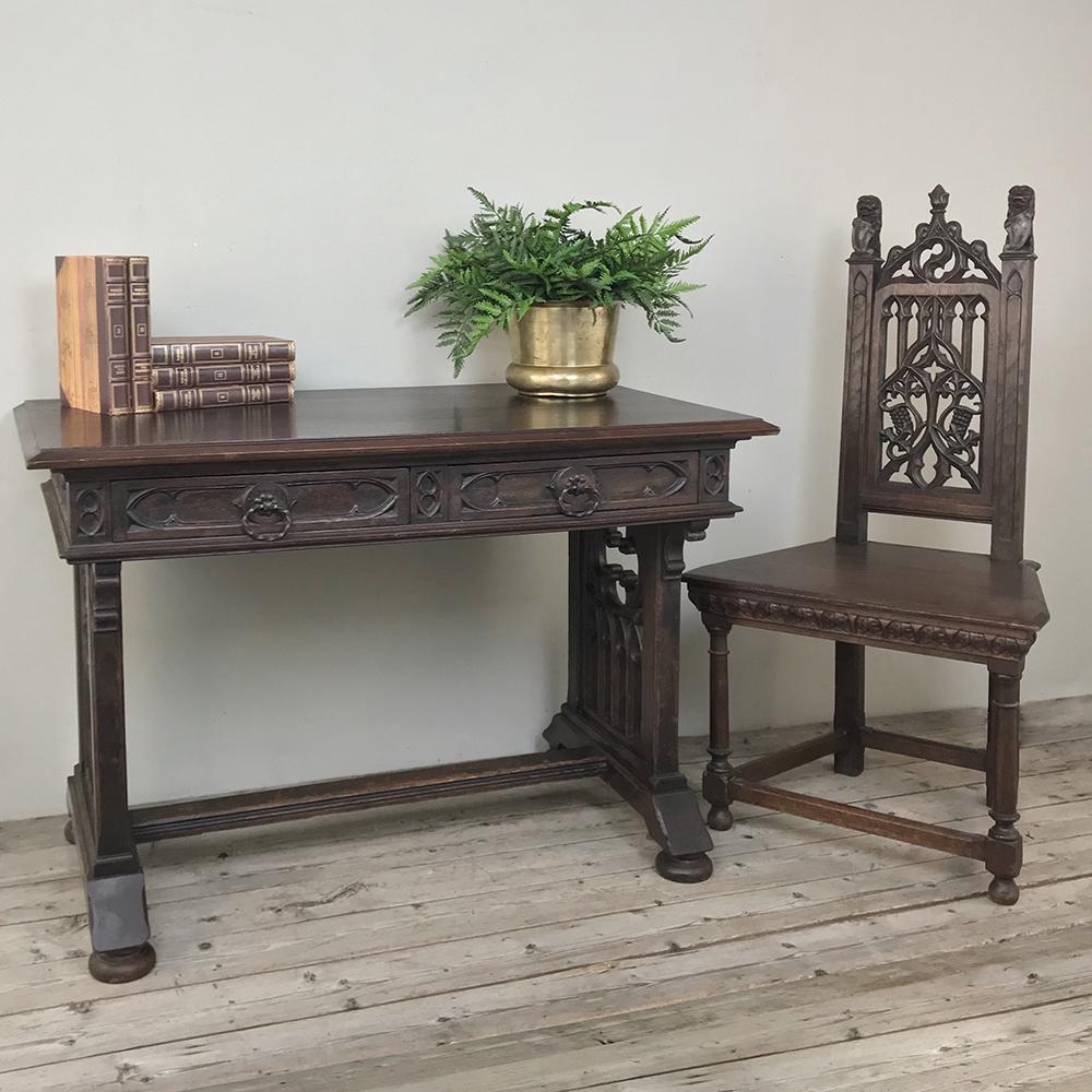 19th century French Gothic writing table was sculpted from solid oak to last for generations, and features the timeless style that has enraptured the world since the middle of the 12th century! Carved all around, it's suitable for placement even in