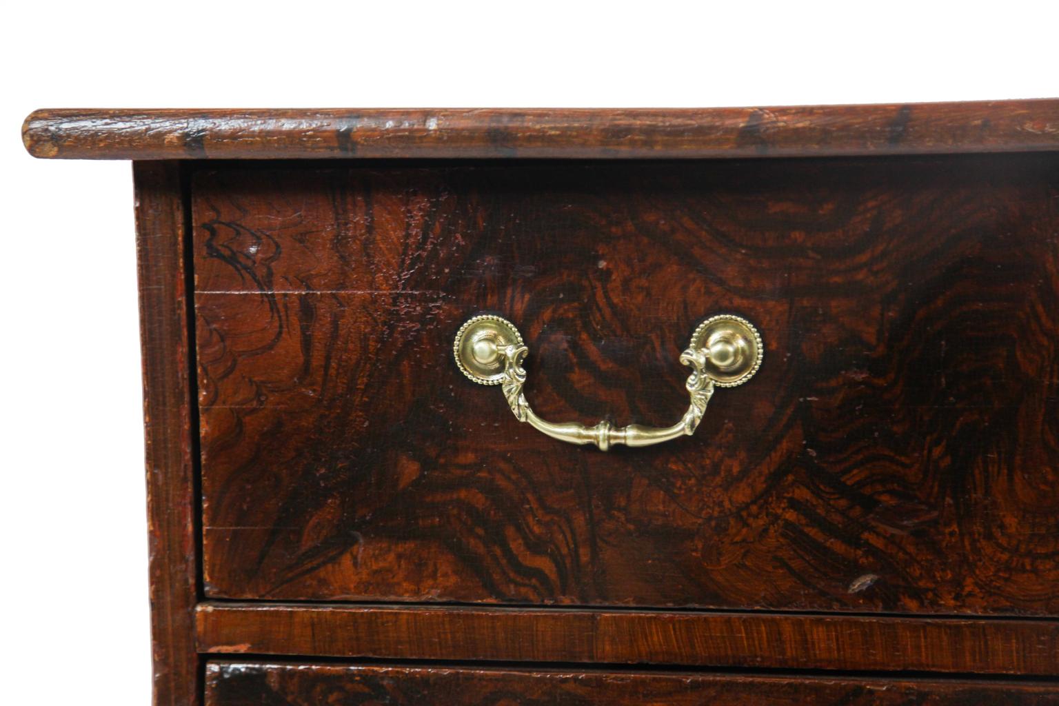 19th century French grain painted bow front chest, the top with simulated wood grain and crossbanding, over three drawers with simulated burl grain, swan neck brass pulls and vertical escutcheons, on cabriole legs with splayed feet.