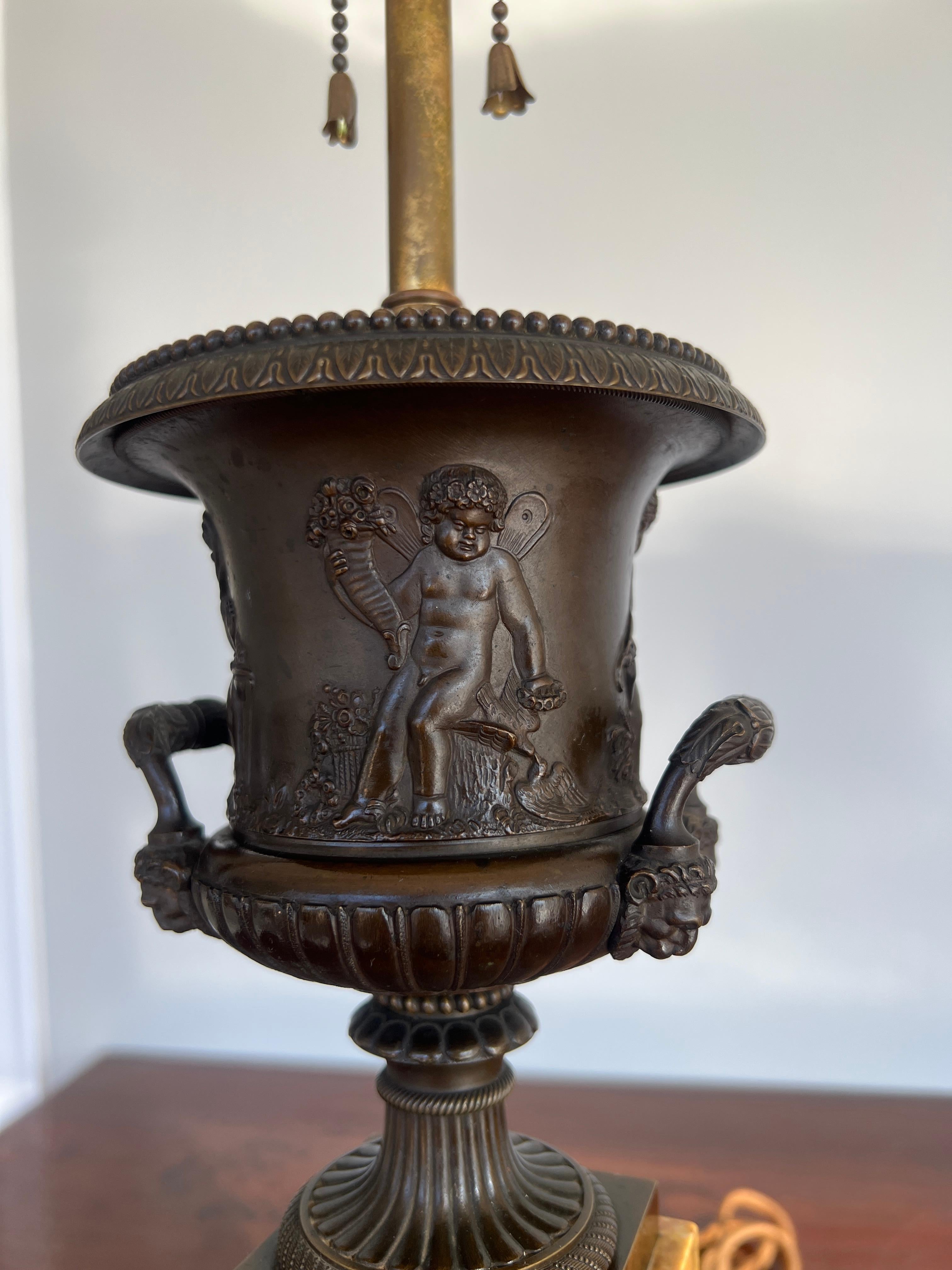 French, 19th century.

A pair of good quality bronze urns decorated with playful cherub or putti. The putti figures each represent one of the four season graces after the original mythology:
Eiar the goddess of Spring: adorned with a flower crown