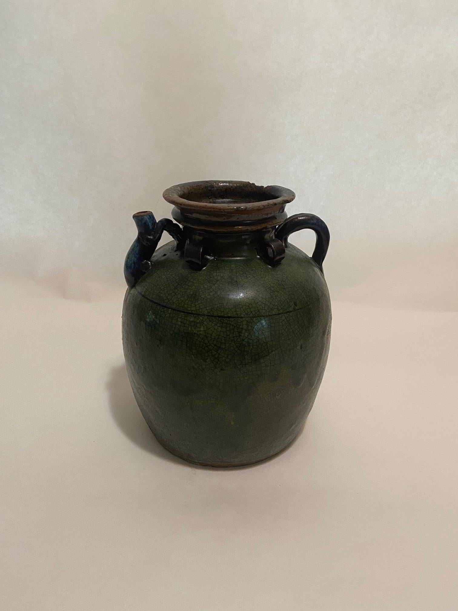 This antique French earthenware jug, with its green glaze, dates from the 19th century, and would originally have been used to store salt. Featuring handles and a pouring spout, this large, hand-thrown jug is in vintage condition. Originally a
