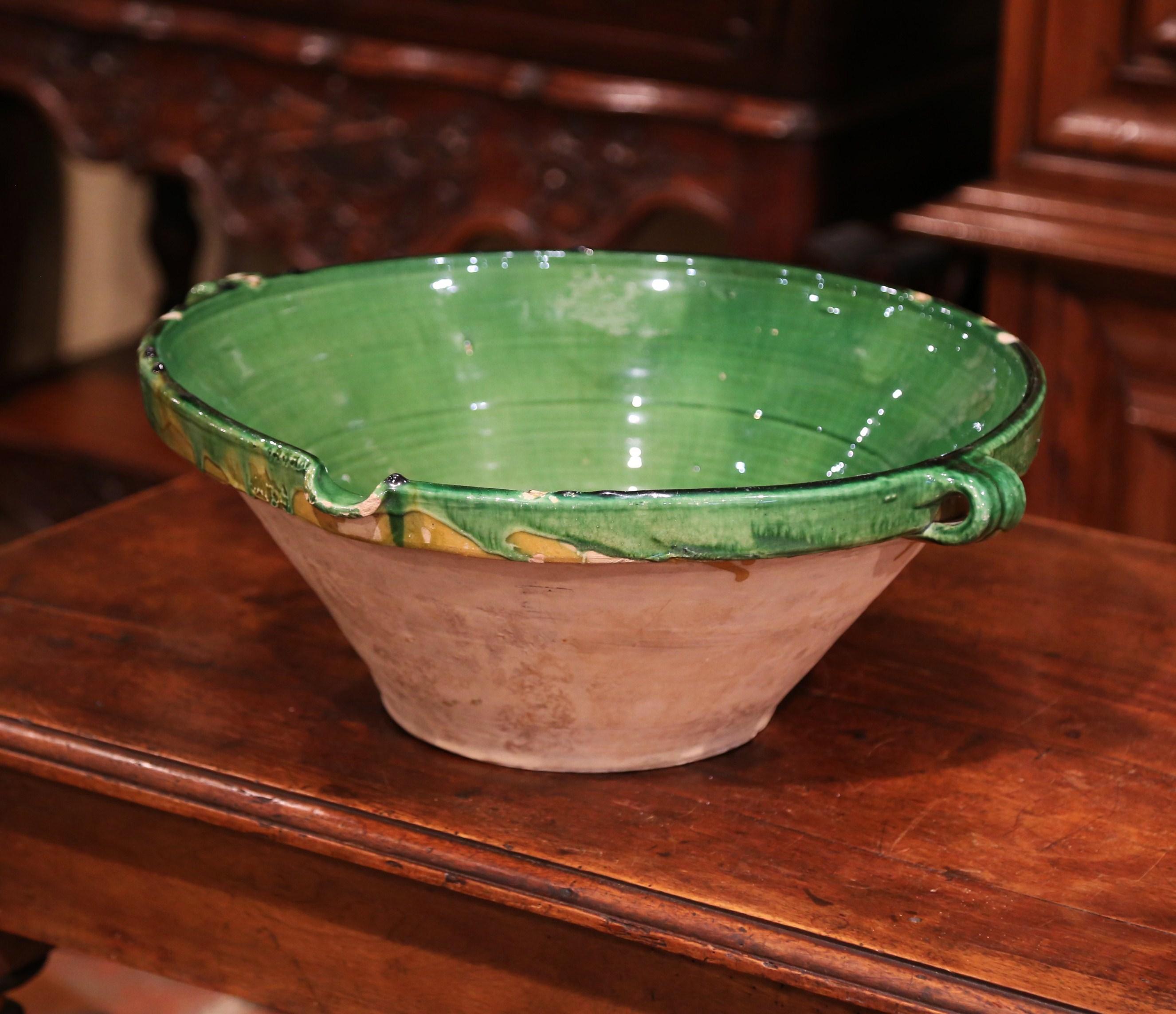 This elegant antique Tian (Provencal term for bowl) was crafted in Provence, France, circa 1870; the round handmade terracotta bowl features two small handles, a server beak, and has a subtle green glaze on the inside with natural earthenware finish