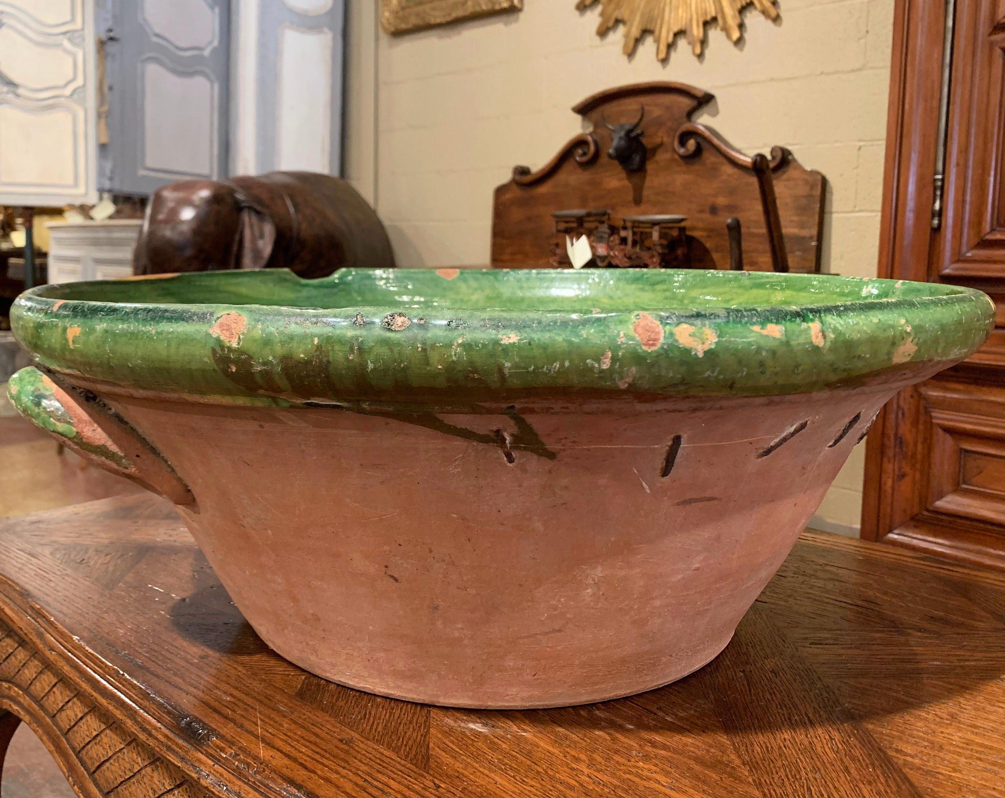 This elegant antique Tian (Provencal term for bowl) from southern France, was crafted in Provence, circa 1870, the round handmade terracotta bowl features a small handle, a server beak, and has a subtle green glaze on the inside with natural
