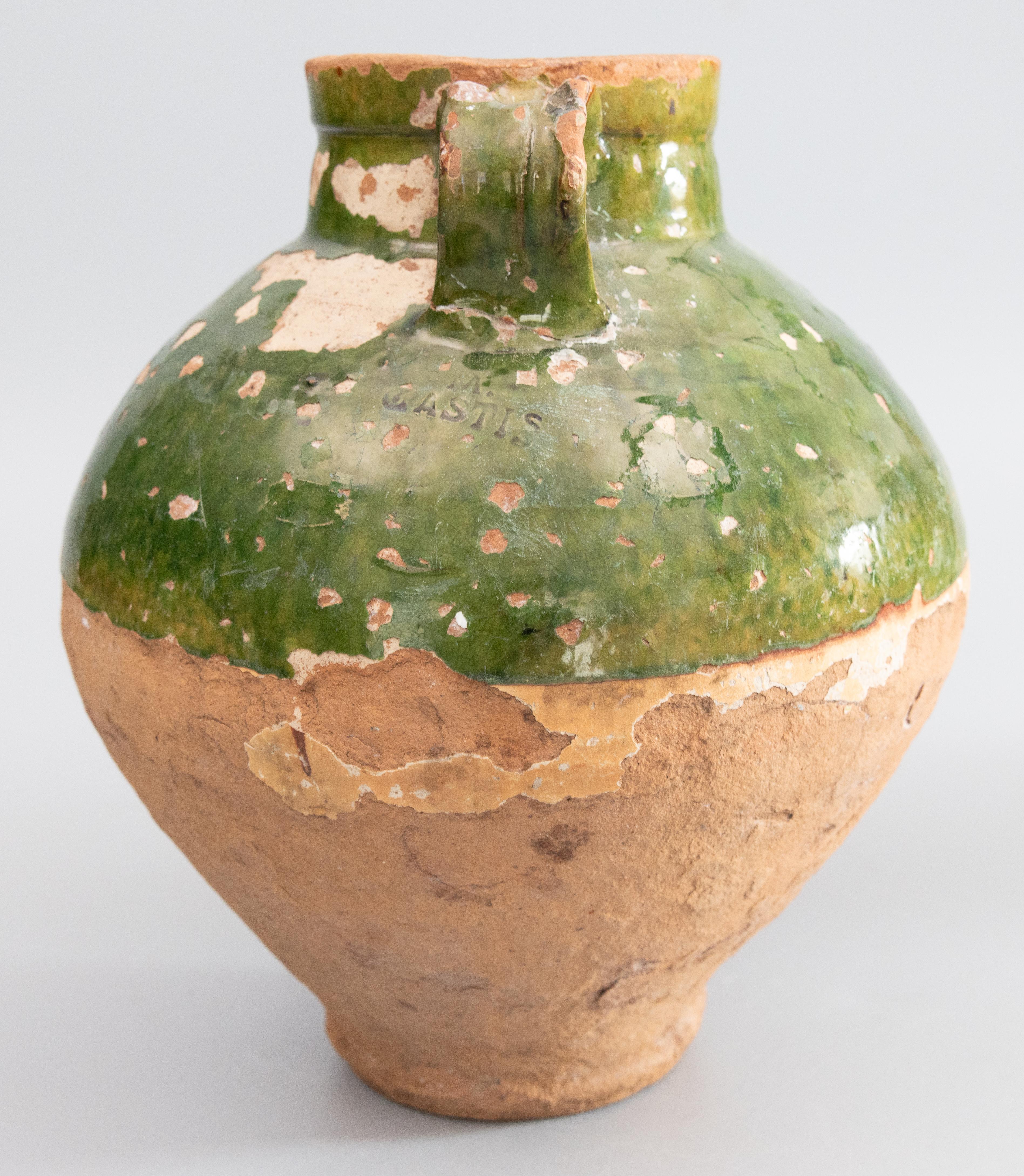 A superb 19th century French Provençal glazed terracotta olive jar or urn. Maker's mark under handle. These jars were used for storing and preserving olive oil. It would be beautiful with a bouquet of flowers or displayed on its own. These are also