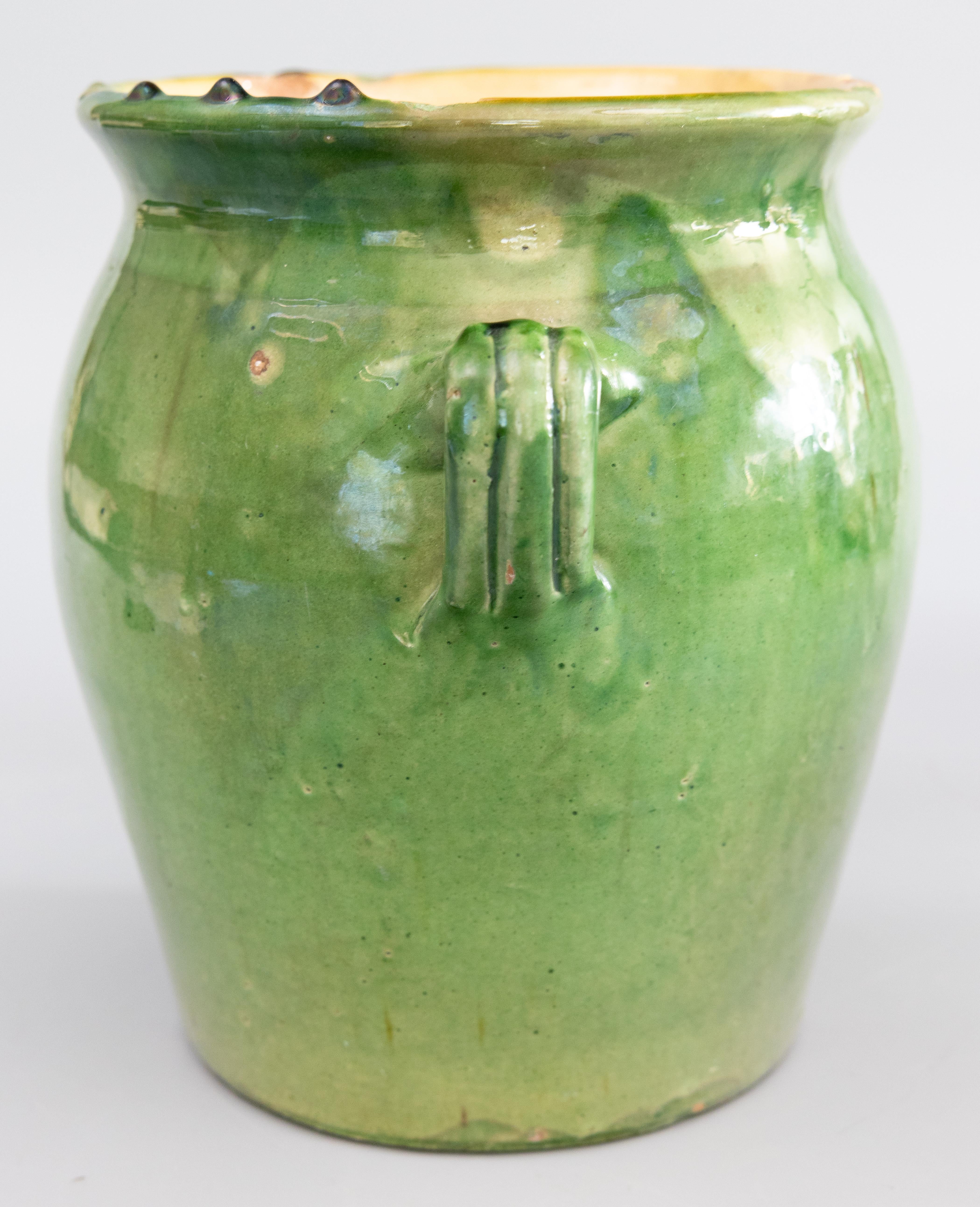 A superb 19th century French Provençal glazed terracotta confit pot / planter / urn / vase / cachepot / crock from Provence in southeastern France. This pot or planter is hand thrown with charming handles known as 'ears' with a lovely green exterior