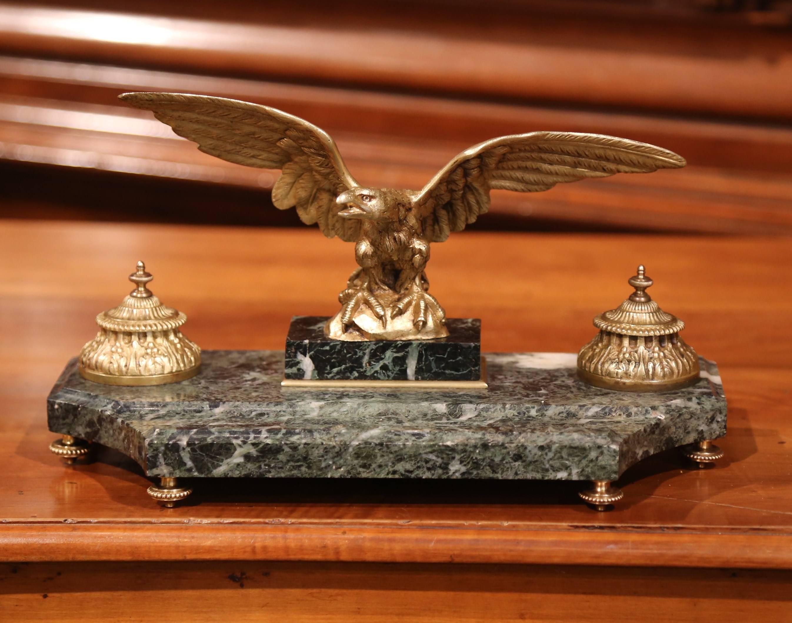 Decorate your desk or study with this large inkwell, which was crafted in France, circa 1880. Situated on a curved green marble base, the antique desk accessory features a bronze eagle with wide wings standing on a rock. On either side are two