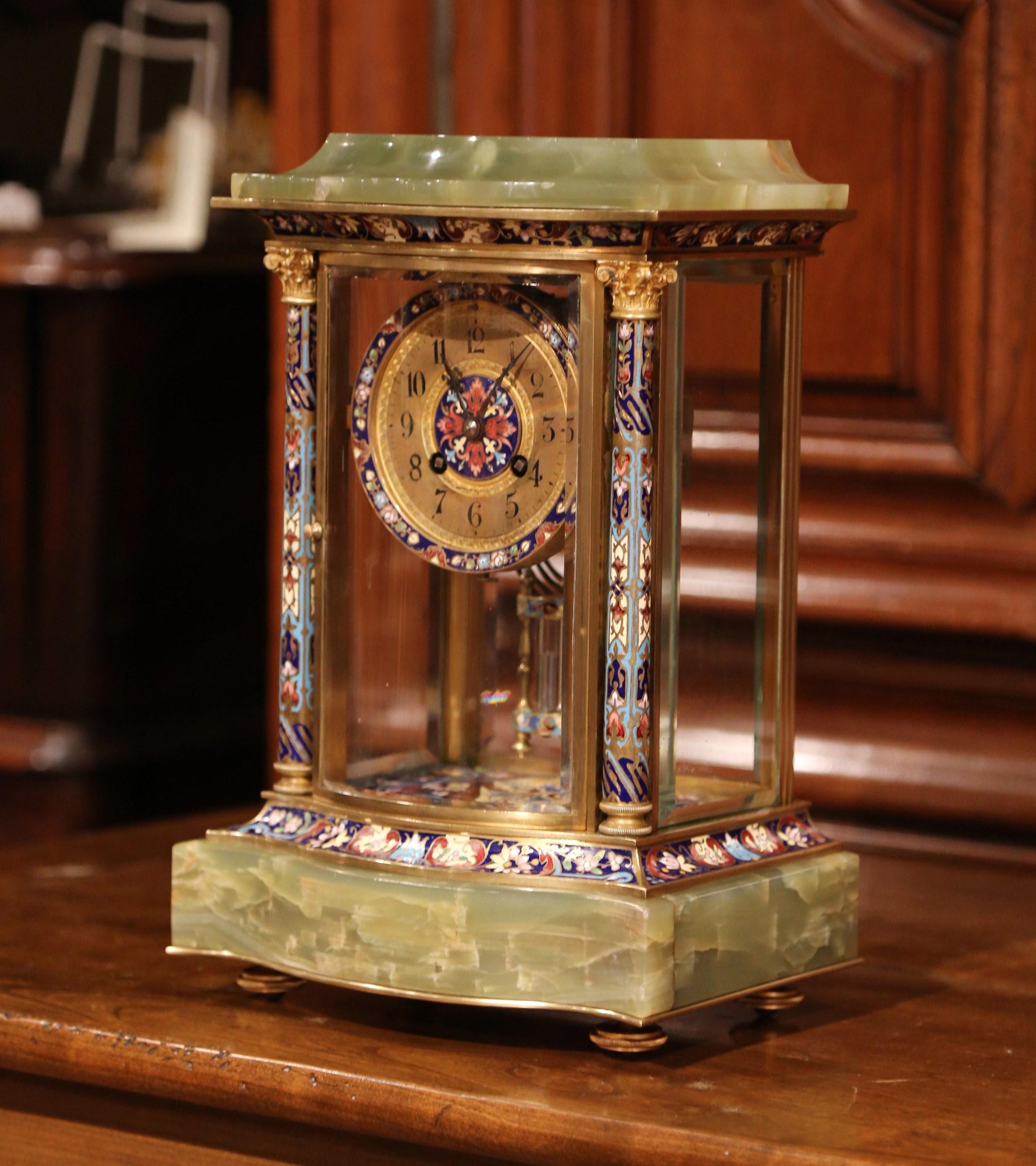 This antique and colorful clock was crafted in France, circa 1870; set on a rectangular onyx base, the elegant time keeper features four cloisonne and champleve enamel columns with bronze rings, a circular center clock with French mechanism marked