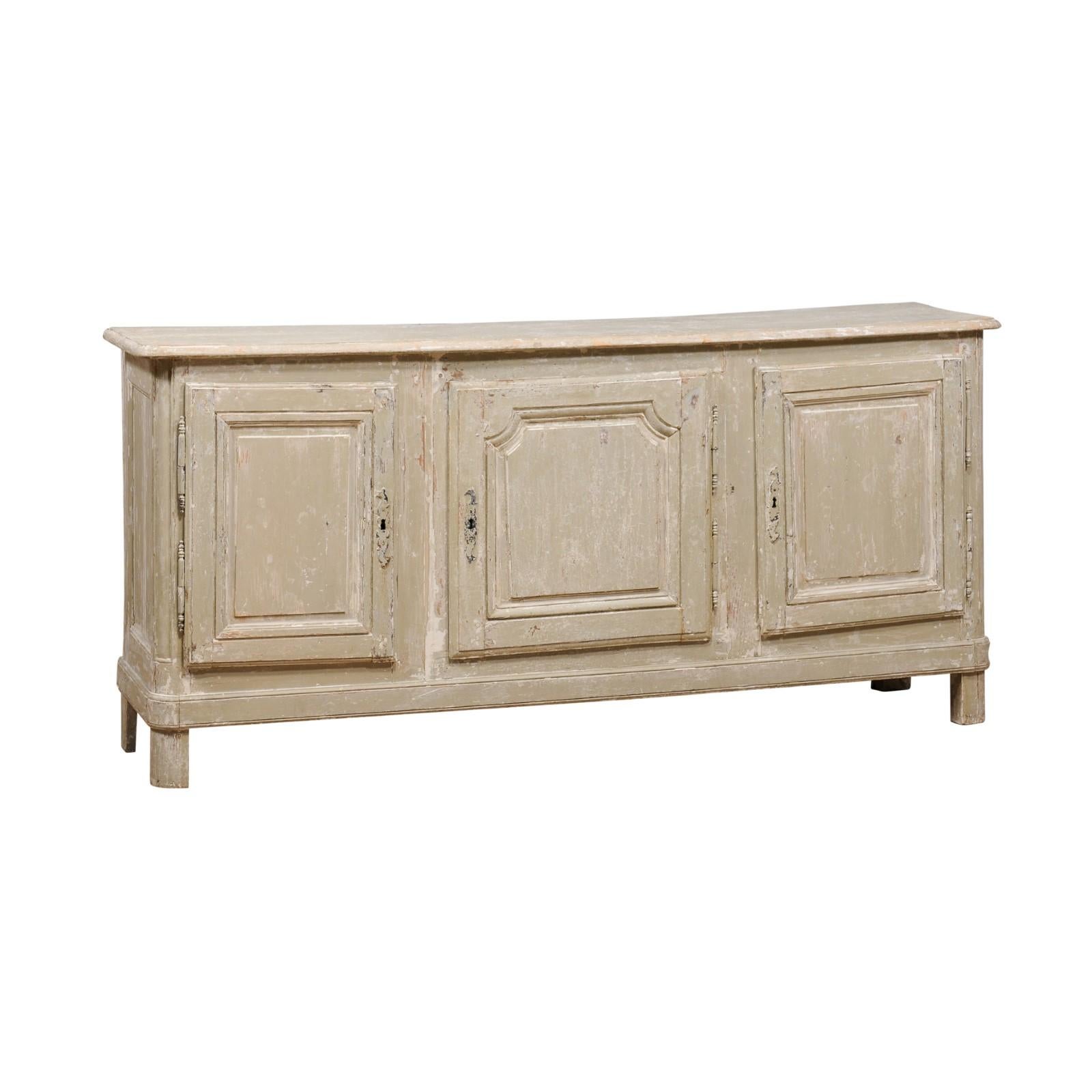 A French grey/beige painted enfilade from the 19th century with three doors and rustic character. Embark on a journey through time with this 19th-century French enfilade, a symphony of rustic character and understated elegance. Coated in an
