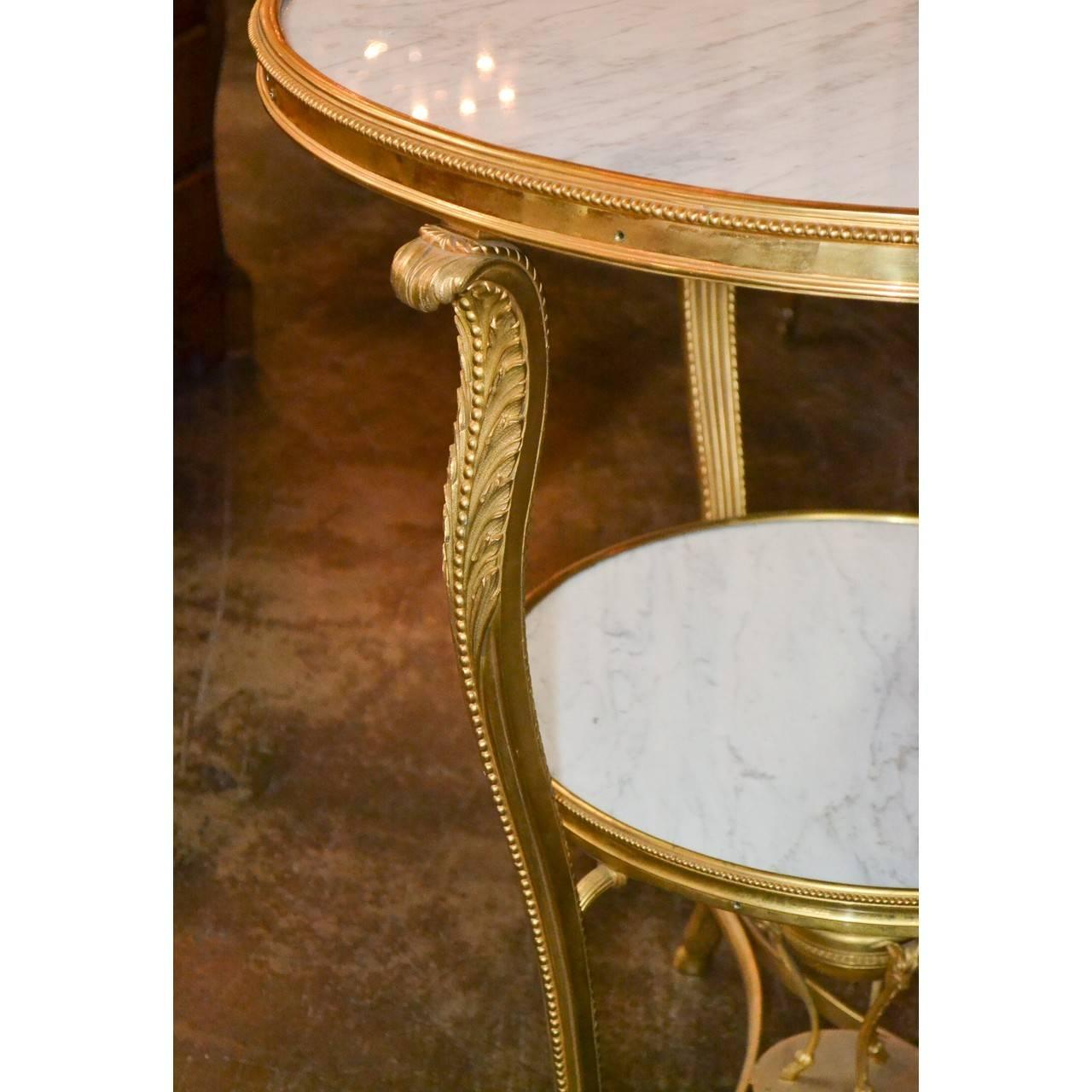 Superior quality 19th century French gilt bronze gueridon table or side table. The two graduated tiers bound in brass and inset with fine white Carrara marble supported by superbly cast acanthus leaf motif gilt bronze contoured legs ending in hoof