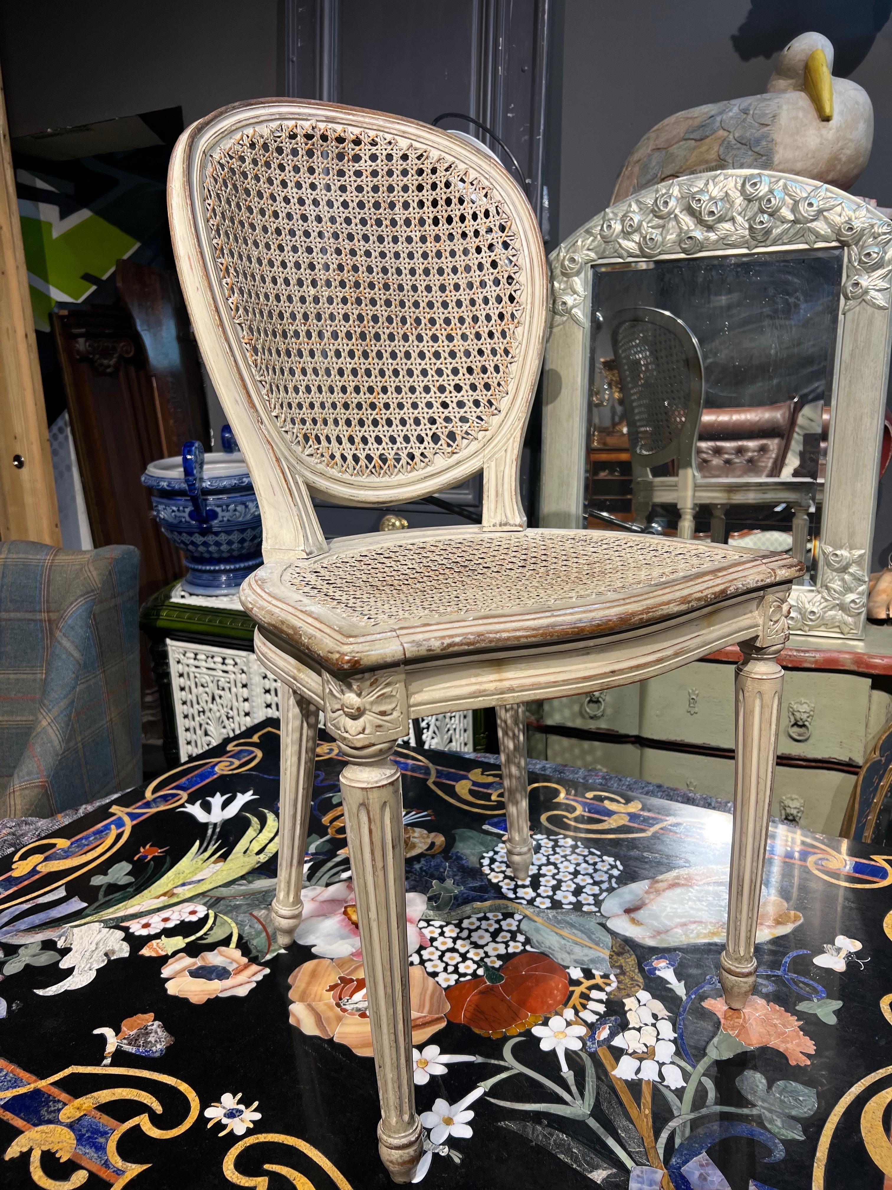 19th Century French hand carved dining chairs delicately hand painted in light grey with original cane seats and backs. The frame of the backs is in oval shape and all of them are in original condition with no restorations ever made. The cane of