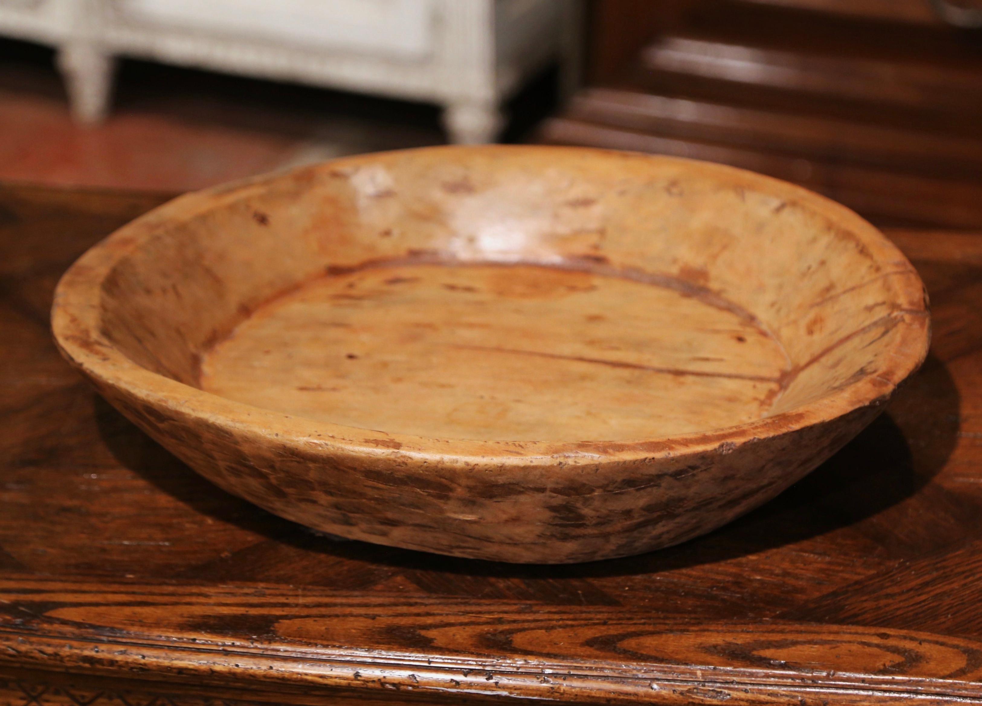 Decorate a dining room table or kitchen counter with this elegant antique center piece filled with fruit or vegetable! Hand carved in France circa 1870 and made of elm wood, the large bowl is almost round in shape and adorns a rich walnut patina.