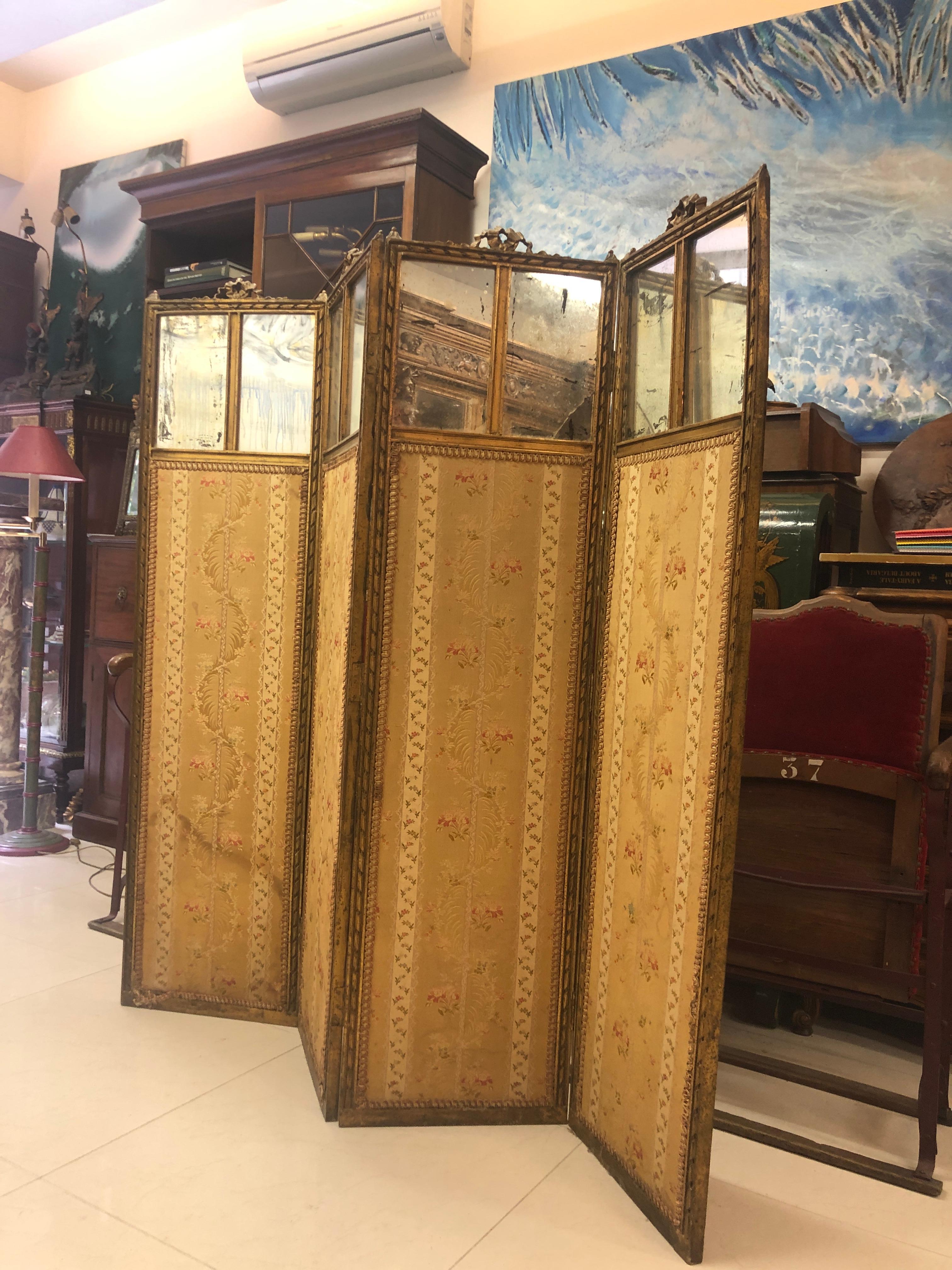 Paravent français à quatre feuilles en bois doré, sculpté à la main et décoré de tores en ruban. Miroirs doubles à la partie haute et tapisserie en soie originale jusqu'au bas de chaque congé. Bon état compte tenu de l'âge, pas encore de