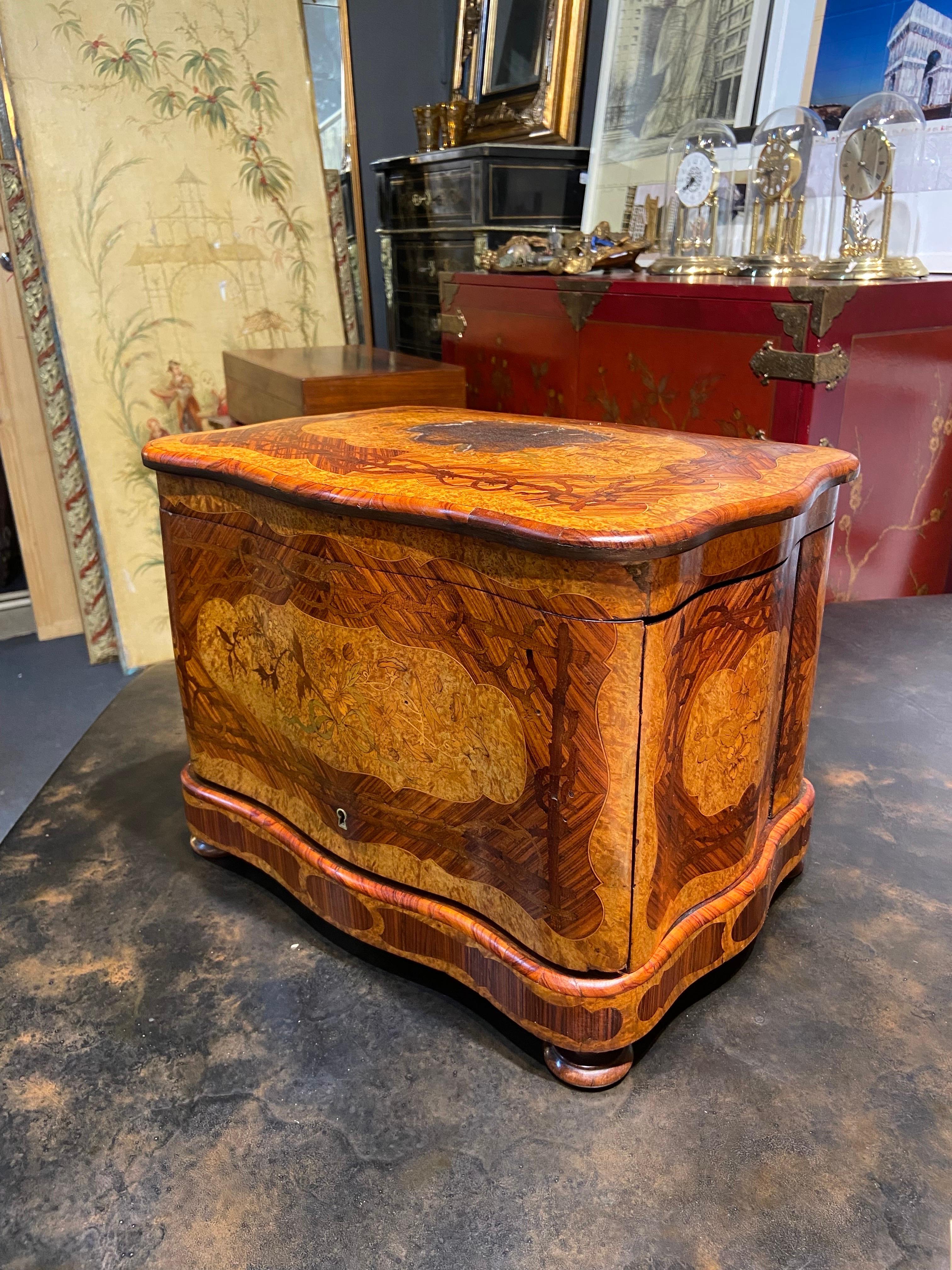 Foldable 19th Century French hand carved marquetry walnut liquor cellar.
Overall good condition except the top of the box which was burned quite bed and no restorations have been made. 
France, circa 1880.
 