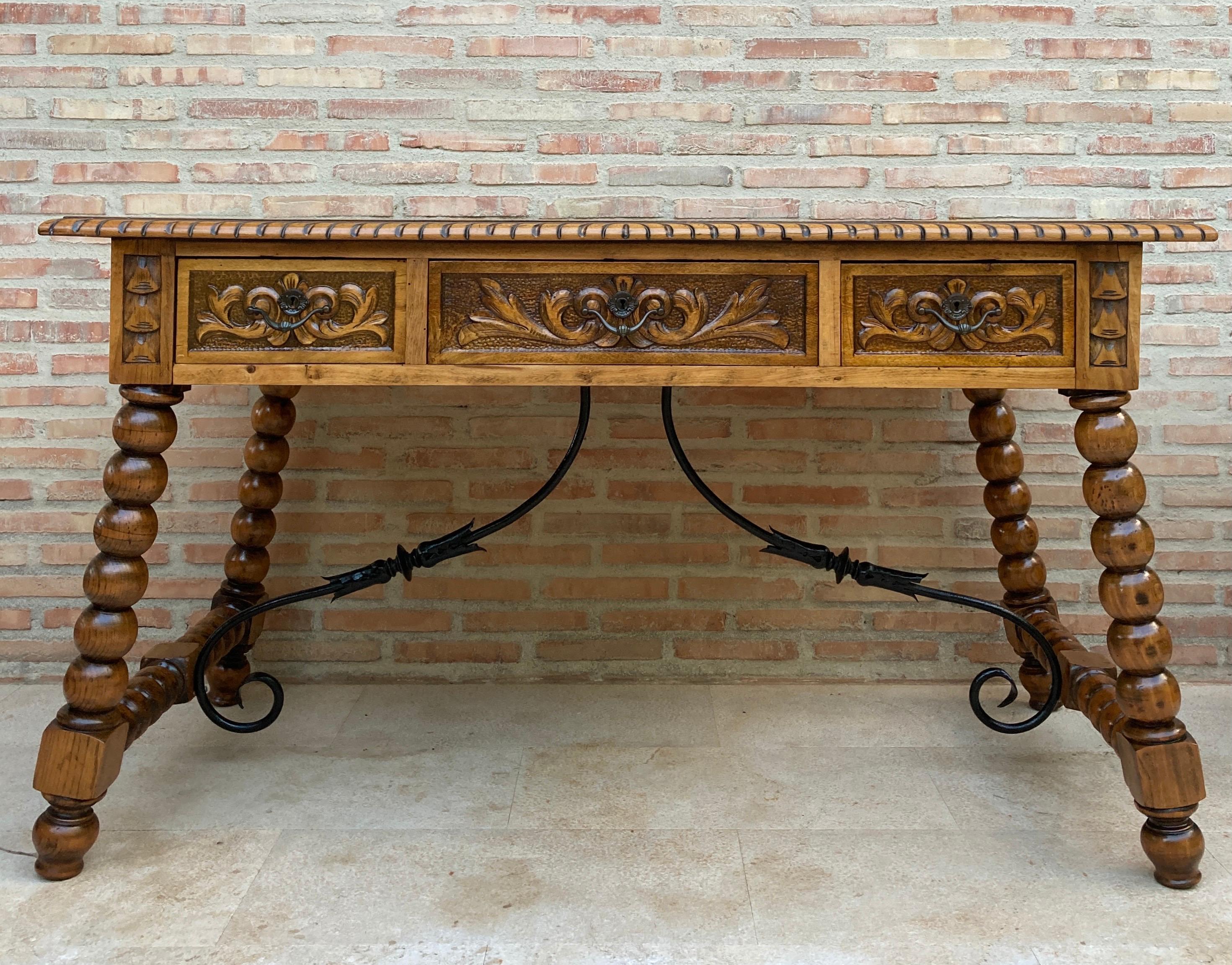 Vintage Design
19th French hand carved oak wood table desk with iron stretcher.
This antique French hand carved oak wood desk features a beautiful carved wooden top on the side of the table embossed in a buttery camel color. The base has