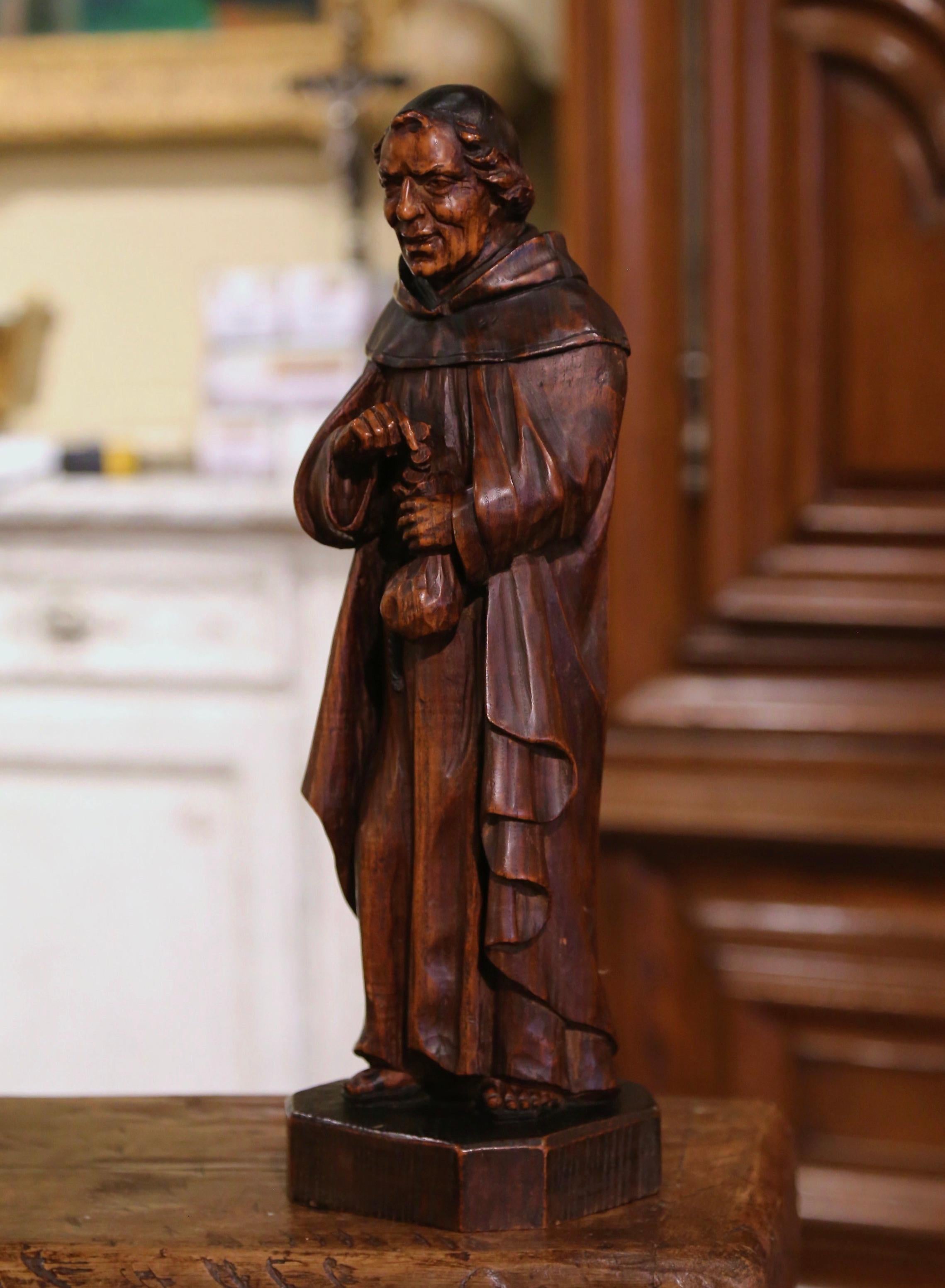 Decorate a bar counter, a study or a wine cellar with this large antique wood figure. Crafted in Southern France, circa 1890, the carved figurative sculpture stands on an integral square base, and features a standing monk in traditional cassock and