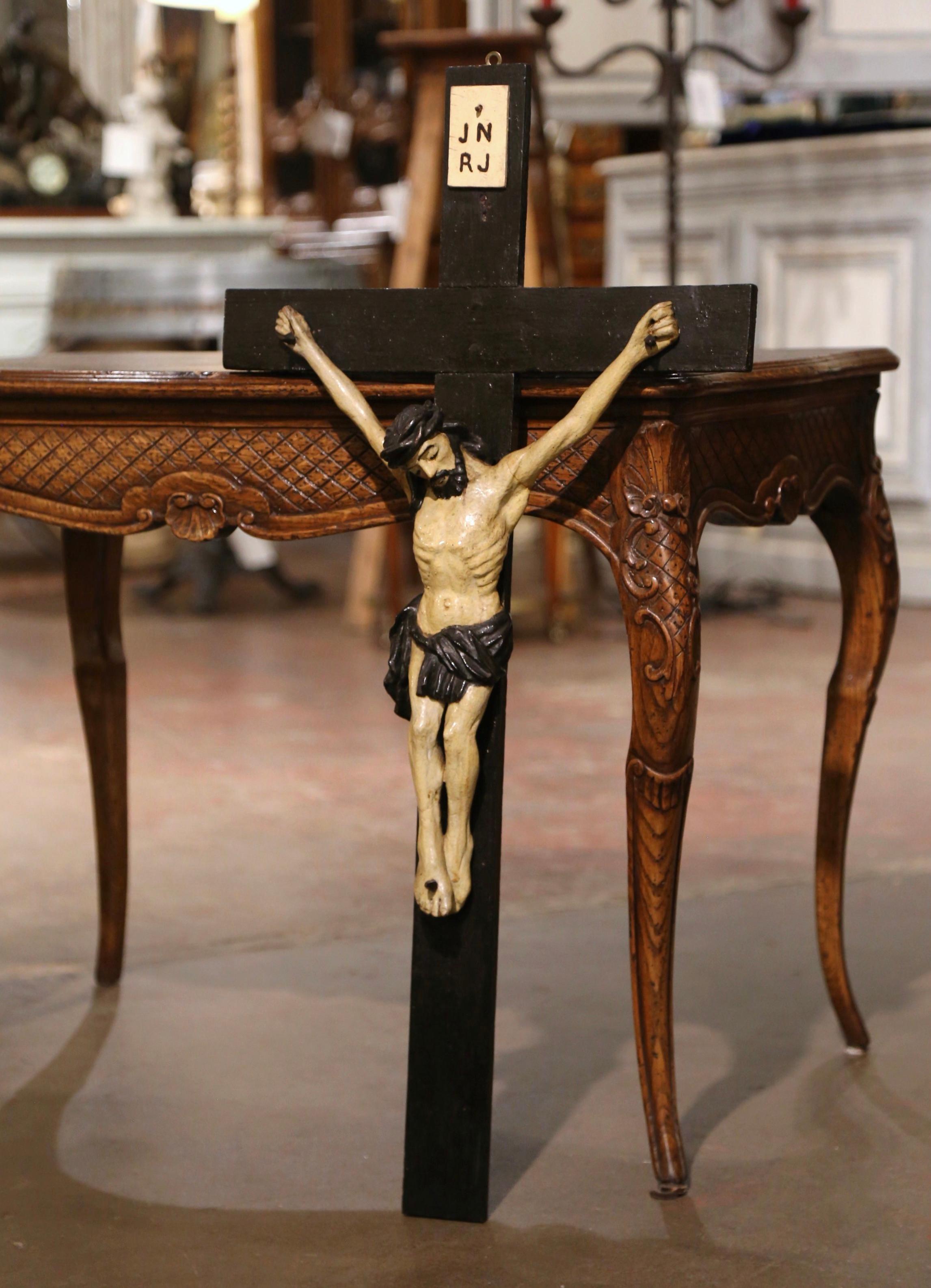 Diese antike geschnitzte Statue des an das Kreuz genagelten Christus wurde um 1850 in Frankreich hergestellt. Das große Kreuz, das in einer Privatkapelle im Rhonetal gefunden wurde, zeigt eine detaillierte, handgeschnitzte Skulptur von Jesus, der