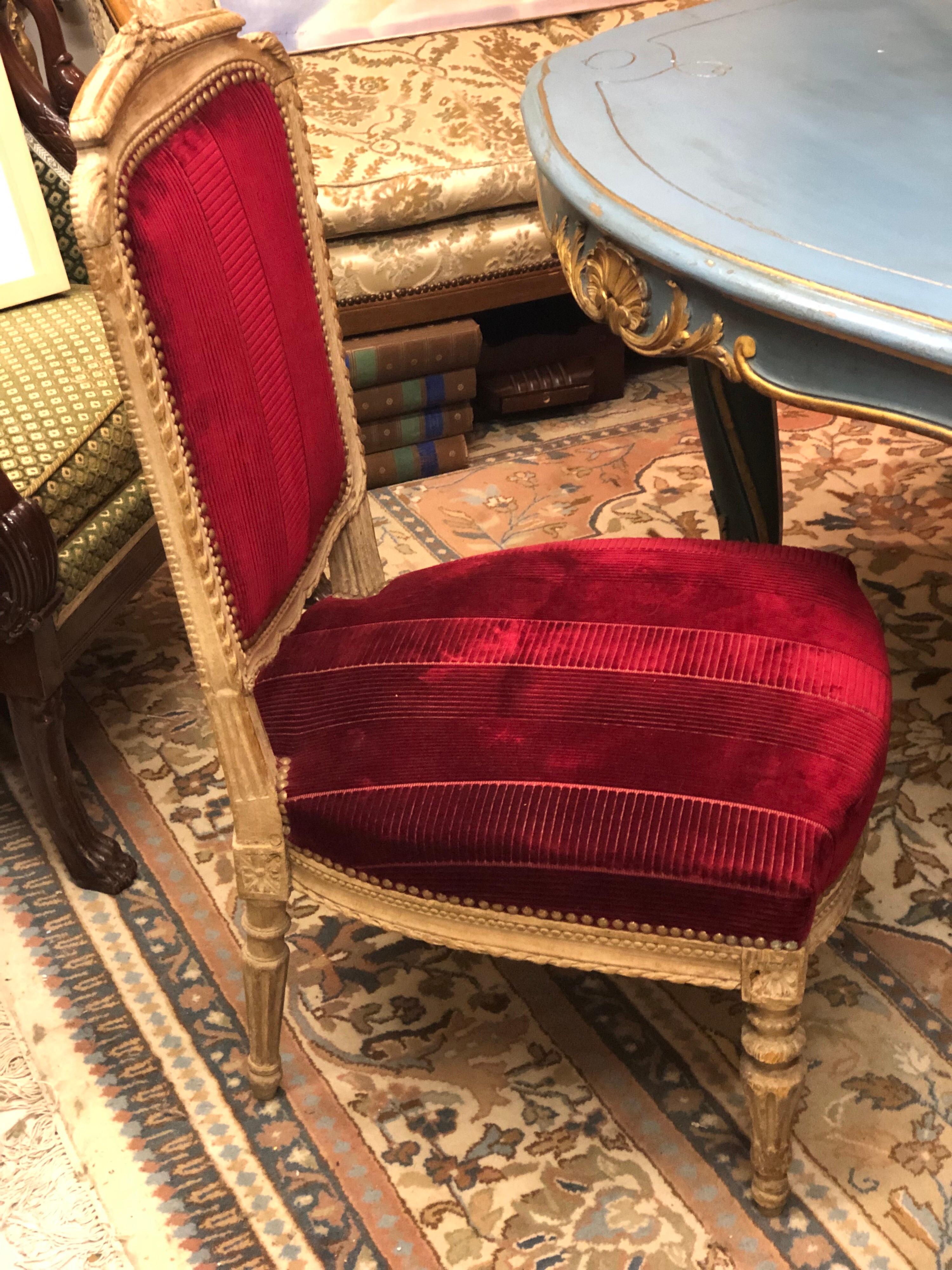 Chaise française à assise basse, sculptée à la main, peinte en beige clair, avec une décoration élégante dans une tapisserie rouge et en très bon état.
Fin du 19e siècle.
 