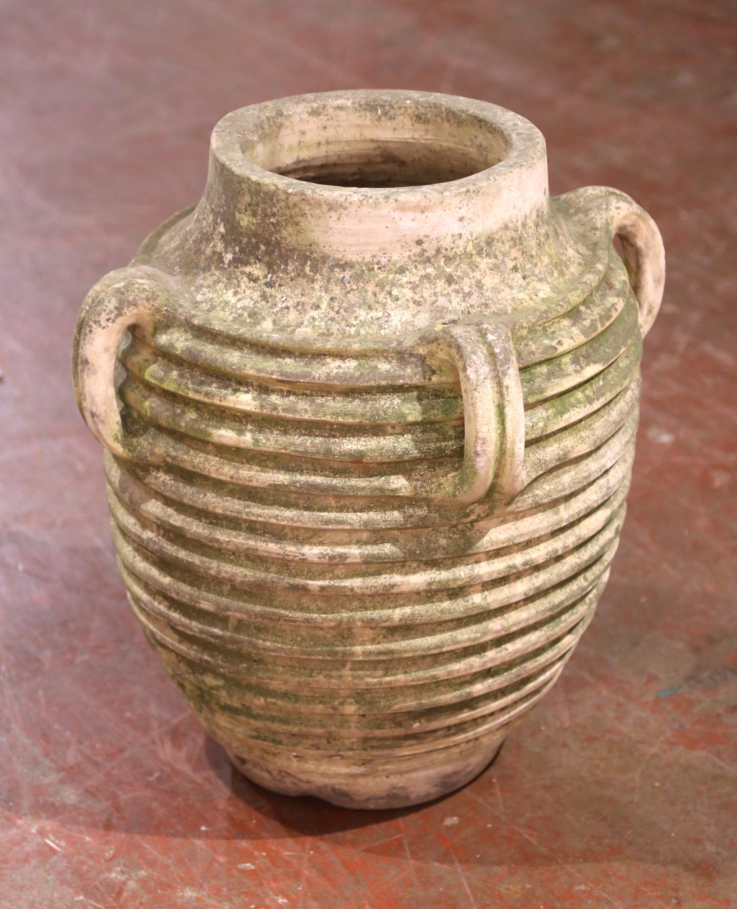 Dieser antike Olivenkrug wurde um 1880 in Frankreich nach traditionellen Methoden aus Terrakotta handgefertigt. Die großzügige, abgerundete Form weist einen tief gerippten Korpus auf, der sowohl die Haltbarkeit als auch den skulpturalen Reiz erhöht.