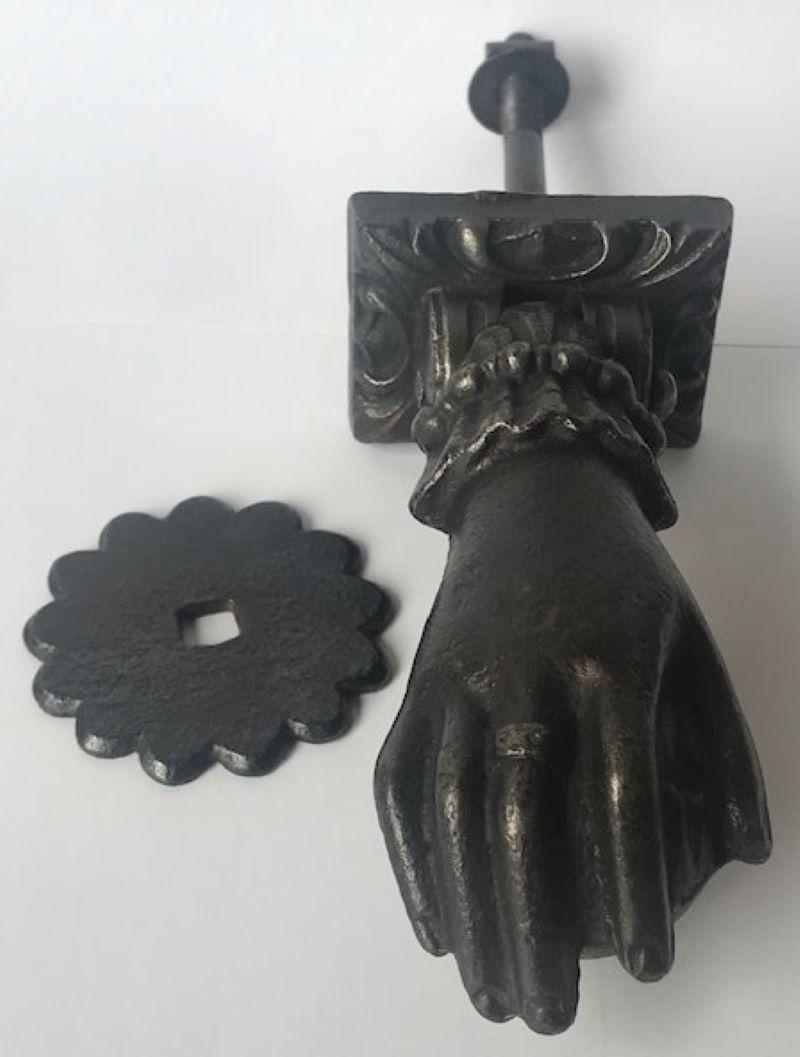 Classic French cast iron door knocker, in the shape of a ladies hand wearing a ring and a beautiful cuff, holding a ball. The set includes a flower shaped plate. Made in the mid to late 19th century.
Measurements taken when hand is hanging down as
